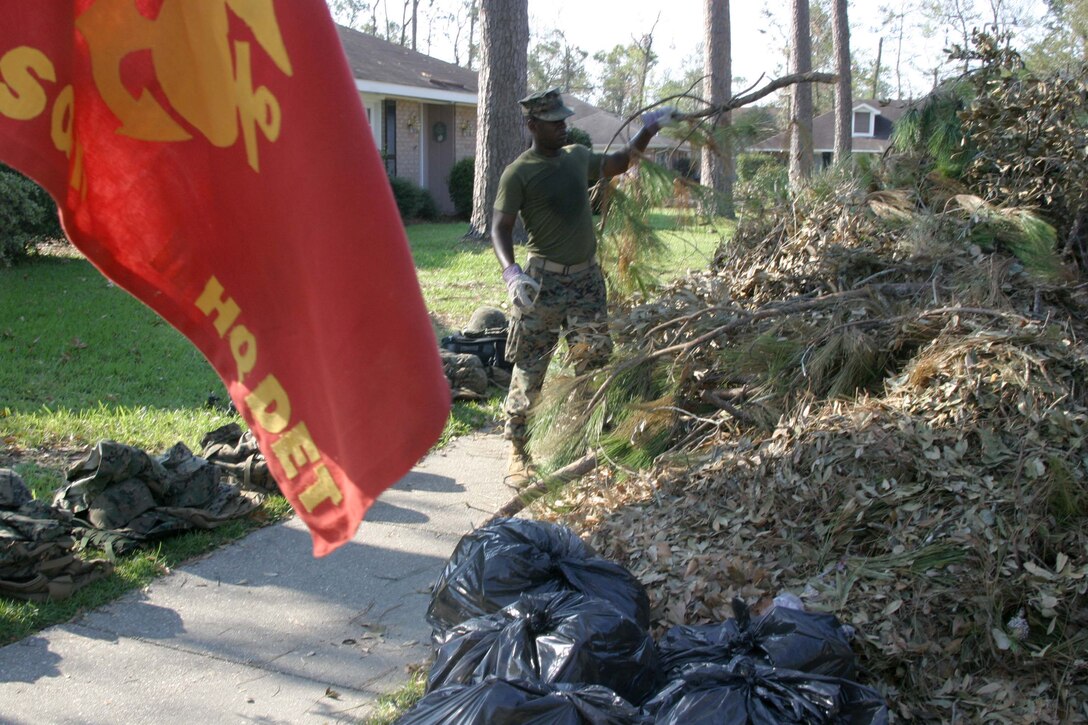 SLIDELL, LA- Lance Corporal Willie A. John with the 11th Marine Expeditionary Unit Service Support Group-11 (MSSG-11), Head Quarters Detachment, Food Service, consolidates broken branches at the front of a small home in Slidell, Louisiana. Marines from the MSSG-11 have been working hard restoring the small town to more livable conditions by breaking down fallen trees, removing debris, and even hauling out furniture from houses ruined by hurricane Katrina. The group, made of 17 Marines, has five houses to clean today, September 12.The Marines arrived on September 6 and will remain in Slidell, providing support for Joint Task Force Katrina, until returning to Camp Pendleton upon completion of their mission. (USMC Photo by Lance Cpl Daniel J. Klein)