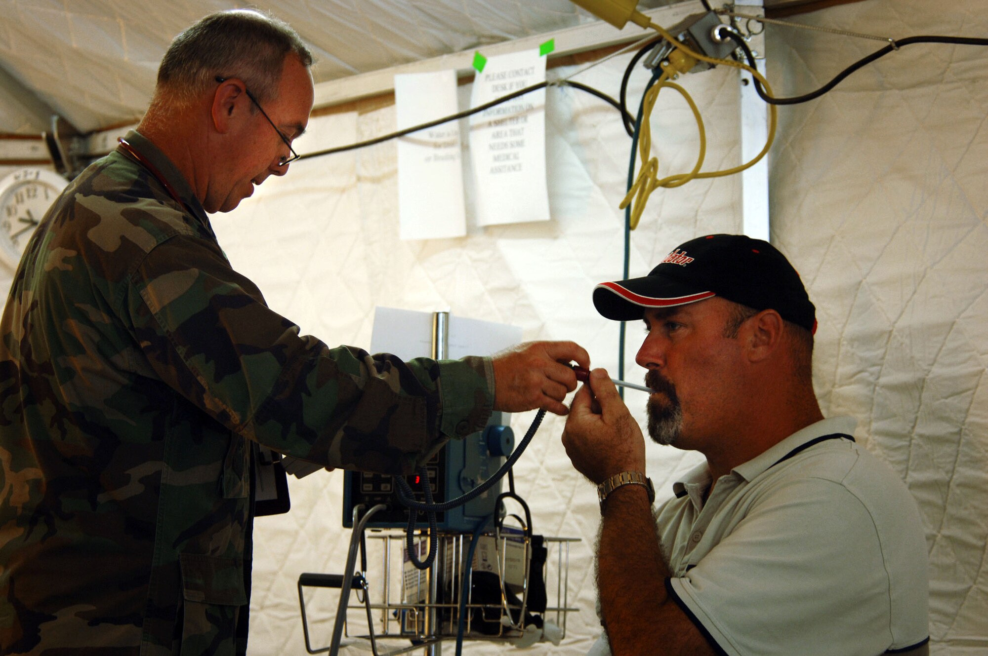 GULFPORT, Miss. -- Capt. Frank Dolifka takes Kirk Moran's temperature before admitting him for treatment at a facility set up outside the Garden Park Medical Center hospital here.  The captain, along with other medical providers with the 81st Medical Group from nearby Keesler Air Force Base, is working with the Federal Emergency Management Agency to provide medical care to victims of Hurricane Katrina.  (U.S. Air Force photo by Master Sgt. Efrain Gonzalez) 