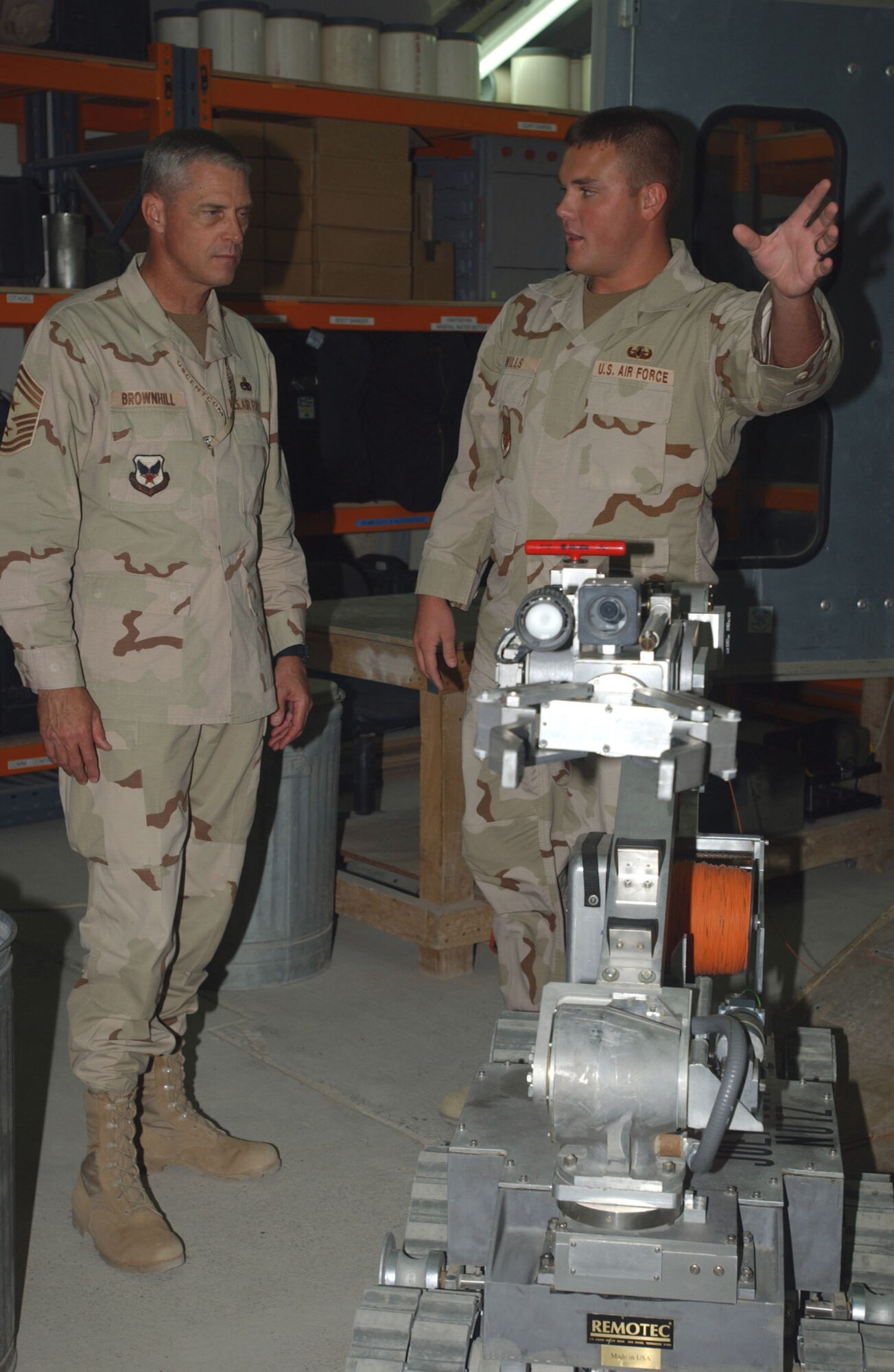 SOUTHWEST ASIA -- Airman 1st Class Joshua Mills (right) explains the capabilities of an explosive ordnance disposal robot to Chief Master Sgt. Curtis Brownhill, the command chief for U.S. Central Command. The chief is touring bases in the CENTCOM area of responsibility.  Airman Mills is assigned to the 380th Expeditionary Civil Engineer Squadron at a forward-deployed location and is from McGuire Air Force Base, N.J. (U.S. Marine Corps photo by Staff Sgt. J.J. Rodriguez)