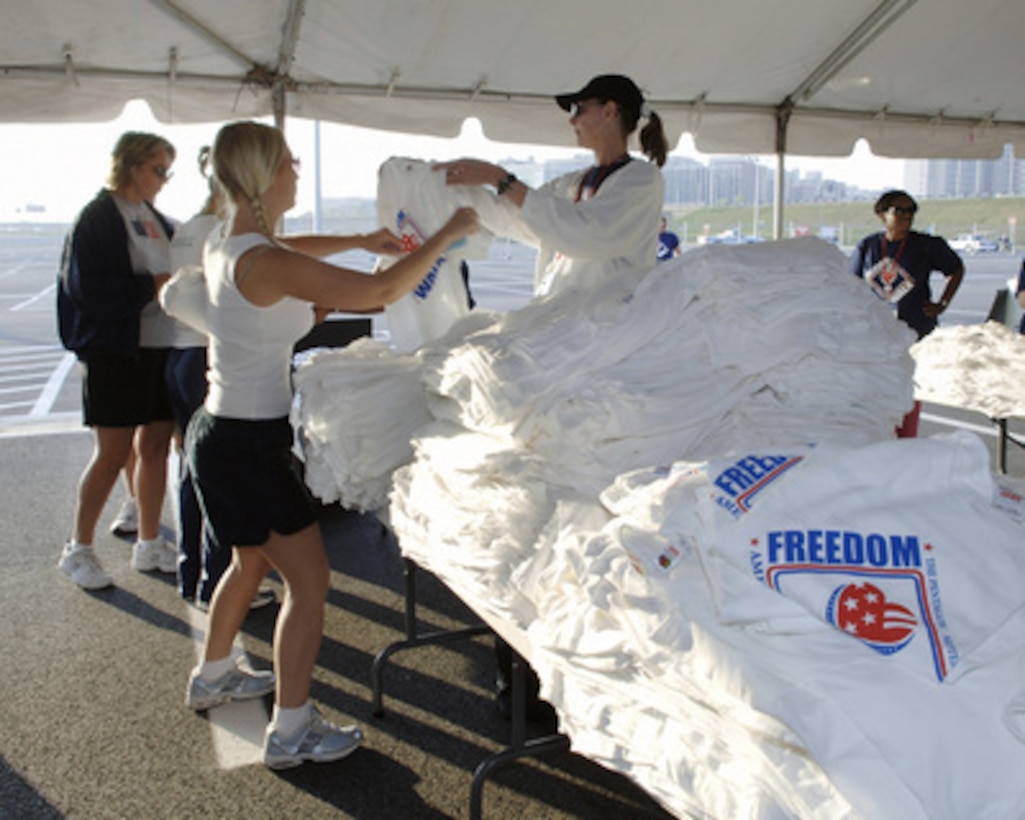 Participants in the America Supports You Freedom Walk receive their commemorative t-shirts at the Pentagon in Arlington, Va., on Sept. 11, 2005. The walk was held in remembrance of the victims of Sept. 11, 2001, and to honor our servicemen and women working to preserve freedom around the world. The walk began near the Pentagon crash site, passed Arlington National Cemetery and proceeded past several National Monuments to conclude on the National Mall by the Reflecting Pool. The participants were invited to attend a musical tribute by country singer and songwriter Clint Black at the end of the walk. 