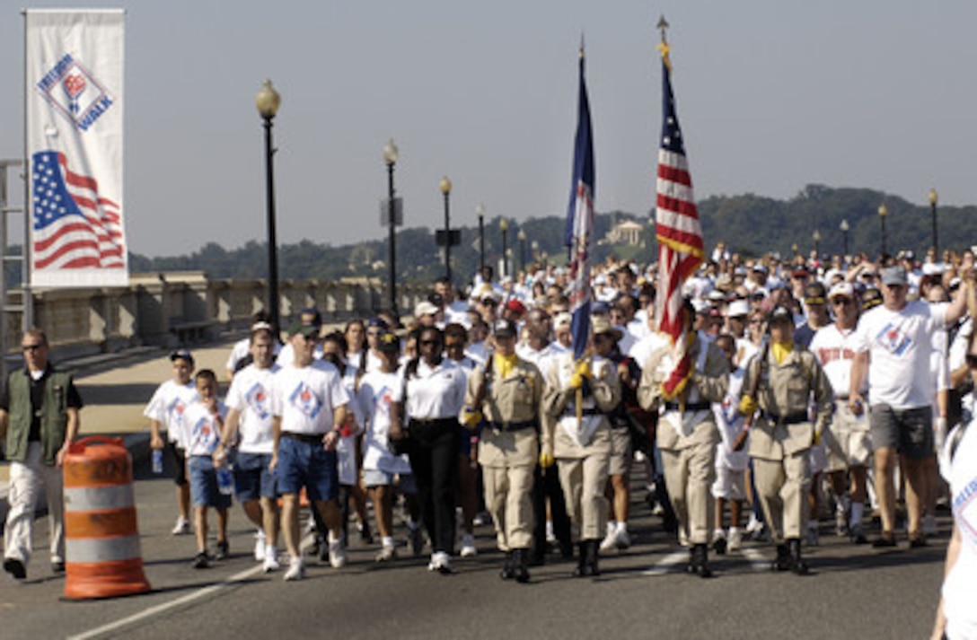 Thousands of people are led by a color guard across the Potomac River on the Memorial Bridge during the America Supports You Freedom Walk in Washington, D.C., on Sept. 11, 2005. The walk was held in remembrance of the victims of Sept. 11, 2001, and to honor our servicemen and women working to preserve freedom around the world. The walk began near the Pentagon crash site, past Arlington National Cemetery and proceeded past several National Monuments to conclude on the National Mall by the Reflecting Pool. The participants were invited to attend a musical tribute by country singer and songwriter Clint Black at the end of the walk. 
