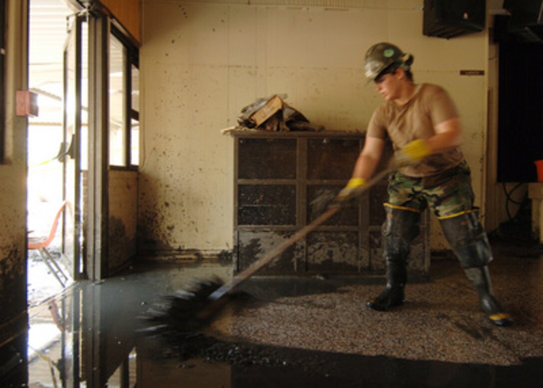 U.S. Navy Seabee Petty Officer 3rd Class Rebecca Newman pushes muddy water from inside the cafeteria at Our Lady of Lourdes Catholic School in Slidell, La., on Sept. 11, 2005. Department of Defense units are mobilized as part of Joint Task Force Katrina to support the Federal Emergency Management Agency's disaster relief efforts in the Gulf Coast areas devastated by Hurricane Katrina. Newman is a Navy builder assigned to Naval Mobile Construction Battalion 4. 