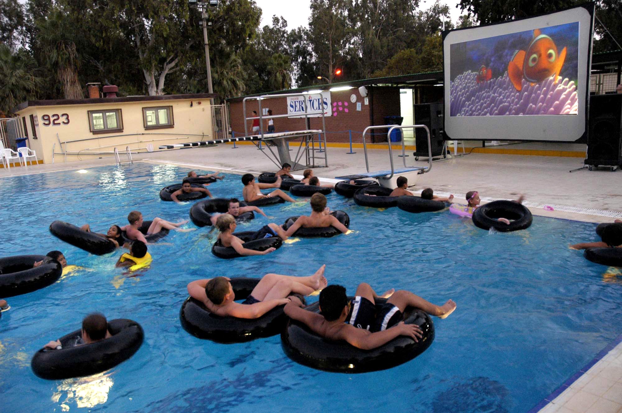 INCIRLIK AIR BASE, Turkey -- Pool goers here had a unique opportunity to beat the heat recently when the 39th Services Squadron hosted its first "dive-in movie" that drew throngs of swimmers and moviegoers to the base pool for a wet evening of entertainment. Perched in deck chairs and inner tubes, about 370 viewers enjoyed "Finding Nemo" and "Jaws." (U.S. Air Force photo by Christopher Skully)