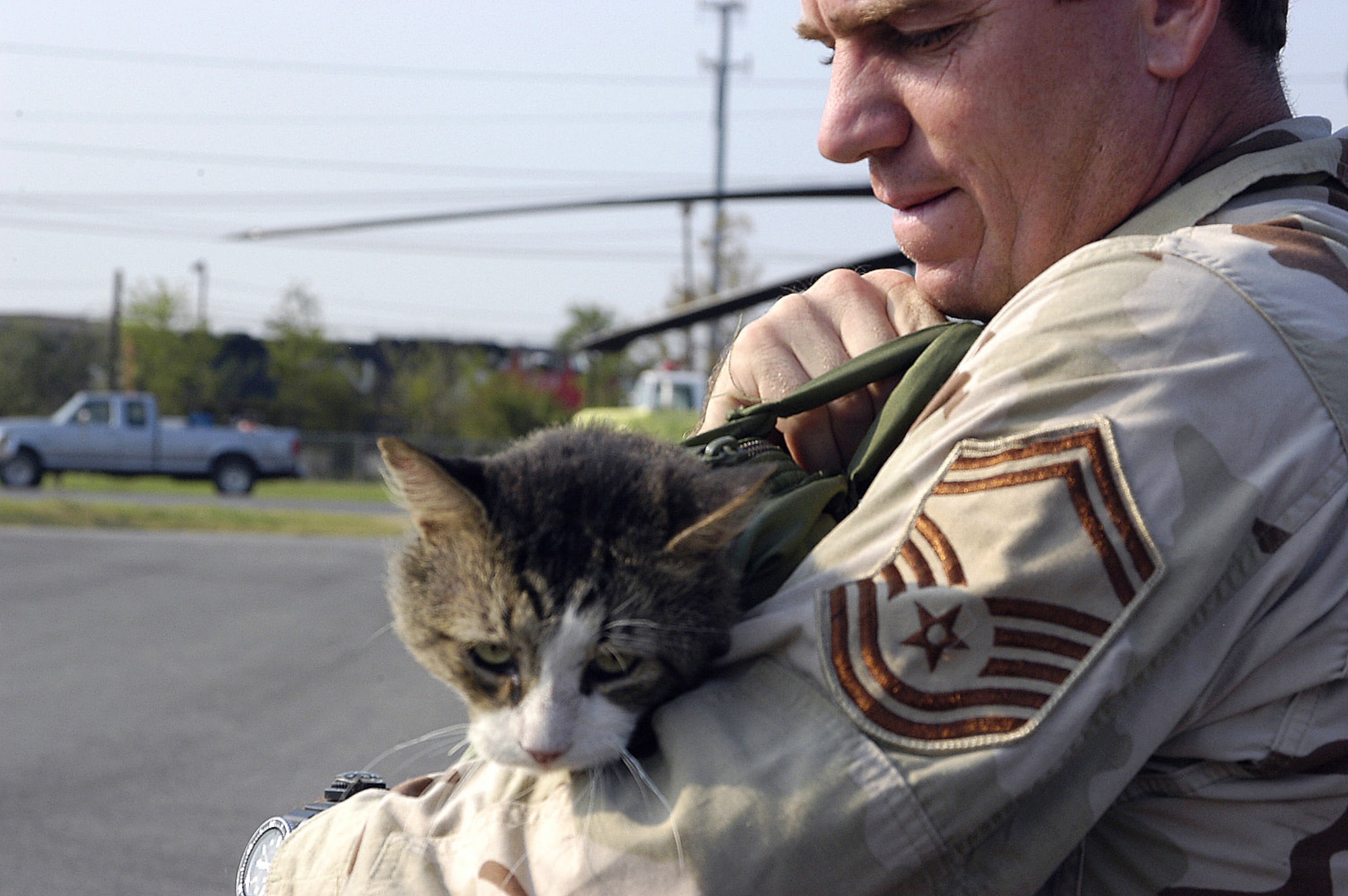 JACKSON, Miss. -- Senior Master Sgt. James Sanchez carries a cat he rescued from the second floor of a flooded house in New Orleans.  The cat, which he named PJ, is one of 22 cats he has saved during rescue missions in support of Hurricane Katrina relief operations.  Sergeant Sanchez is a pararescueman with the 306th Rescue Squadron from Davis-Monthan Air Force Base, Ariz. (U.S. Air Force photo by Senior Master Sgt. Elaine Mayo)