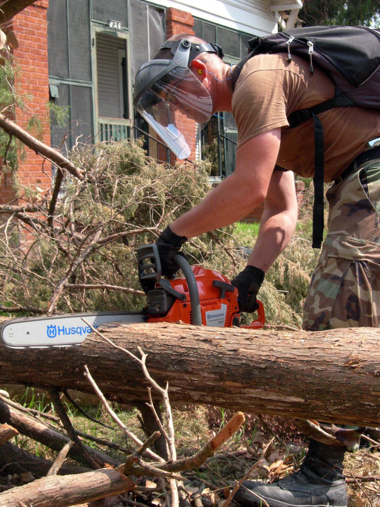 NEW ORLEANS - Staff Sgt. Joshua Copeland cuts through a downed tree in a neighborhood here Sept. 13.  About 100 Airmen from the 4th Expeditionary Civil Engineer Squadron helped clear debris alongside members of the 82nd Airborne Division. Sergeant Copeland is deployed from the 375th CES at Scott Air Force Base, Ill.  (U.S. Air Force photo by Staff Sgt. Bryan Bouchard)