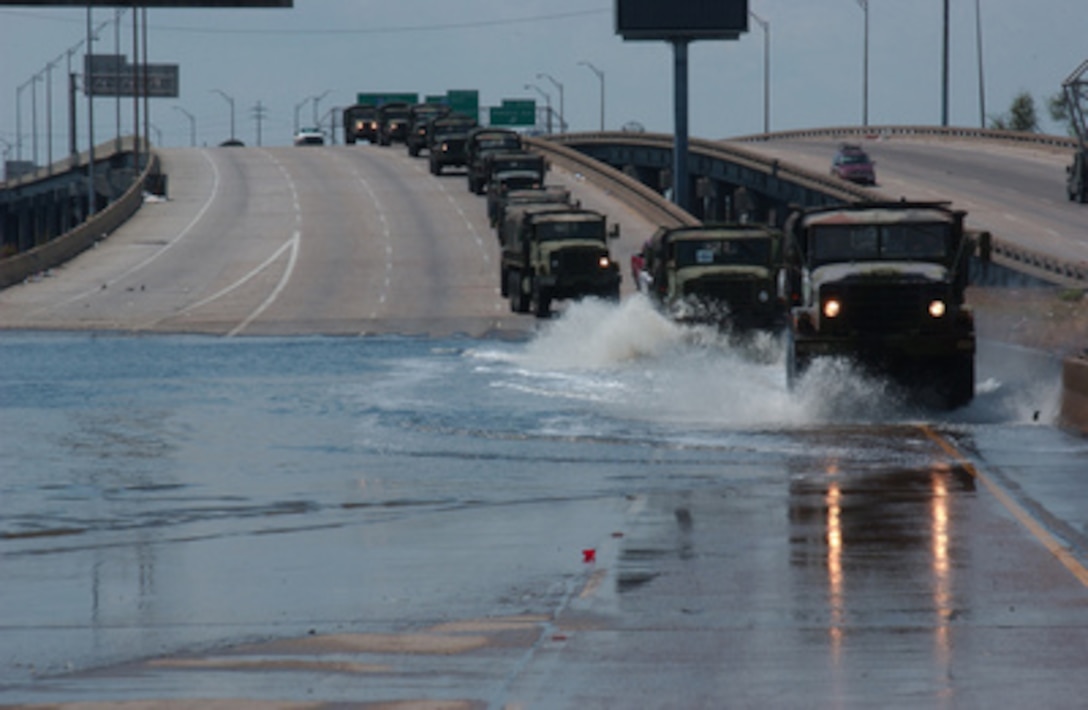 A convoy of military vehicles crosses floodwaters on Interstate 10 to move Texas Air National Guard Security Forces from Francis Gaudet Elementary School to Loyola University in New Orleans, La., on Sept. 11, 2005. Department of Defense units are mobilized as part of Joint Task Force Katrina to support the Federal Emergency Management Agency's disaster relief efforts in the Gulf Coast areas devastated by Hurricane Katrina. 
