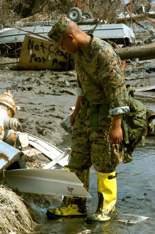 NEW ORLEANS--A Navy corpsman with 1st Battalion, 8th Marine Regiment washes off his waders after patrolling the filthy streets of the 9th District in  St. Bernard's Parish.
