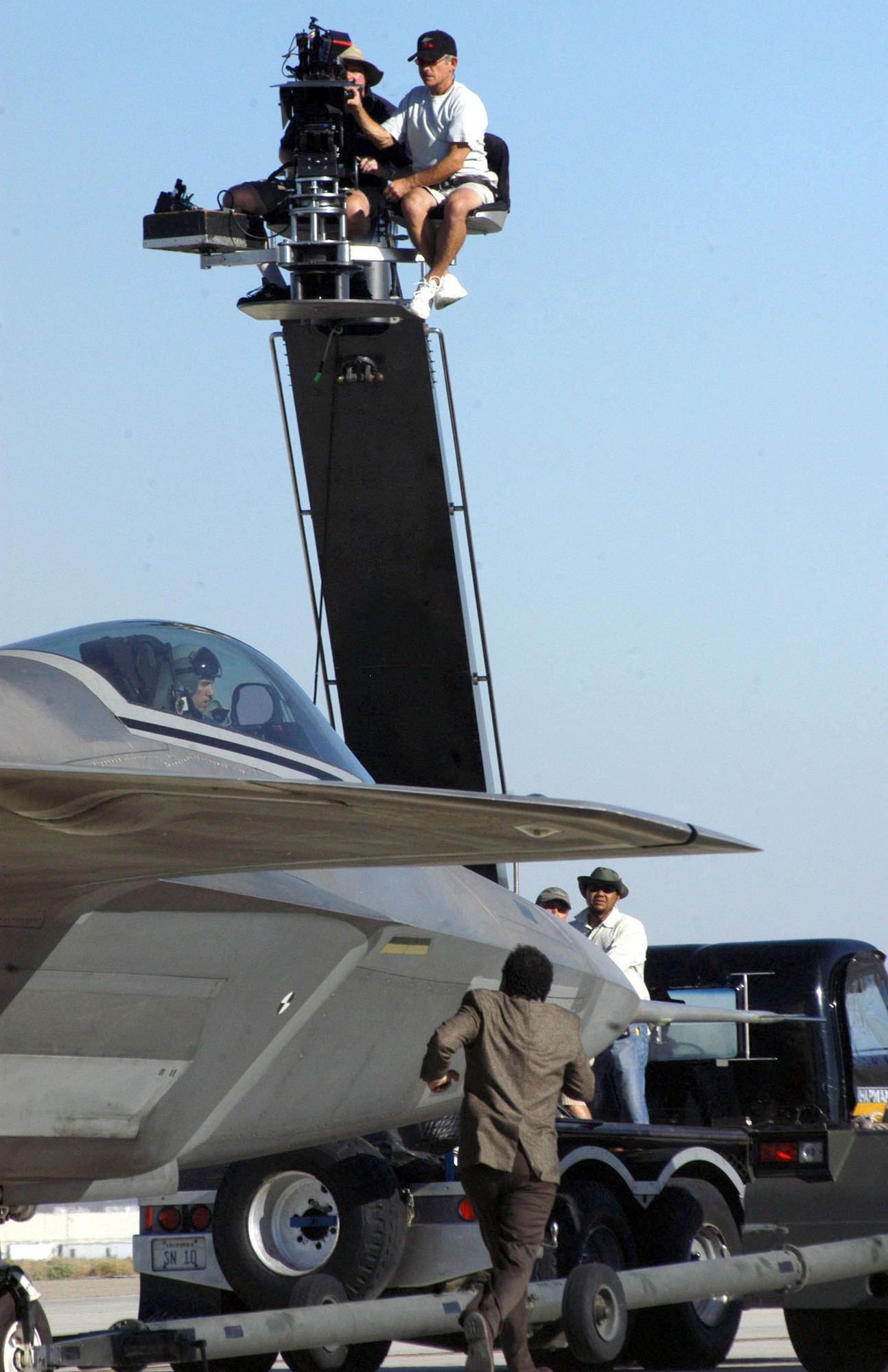 EDWARDS AIR FORCE BASE, Calif. -- NBC Universal cameramen capture the action as actor Tony Shalhoub, who plays detective Adrian Monk, runs to capture the "bad guy" who attempts to escape in an F/A- 22 Raptor during the filming of an upcoming episode of "Monk."  The episode is scheduled to air on USA Network in January 2006. (U.S. Air Force photo by Airman 1st Class Francesca Carrano)