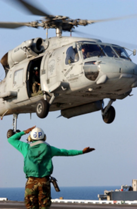 A U.S. Navy landing signal enlisted sends off an SH-60 Seahawk helicopter from the flight deck of the aircraft carrier USS Harry S. Truman (CVN 75) on Sept. 13, 2005. The Truman is currently operating off the Gulf Coast in support of hurricane relief efforts. Department of Defense units are mobilized as part of Joint Task Force Katrina to support the Federal Emergency Management Agency's disaster-relief efforts in the Gulf Coast areas devastated by Hurricane Katrina. 