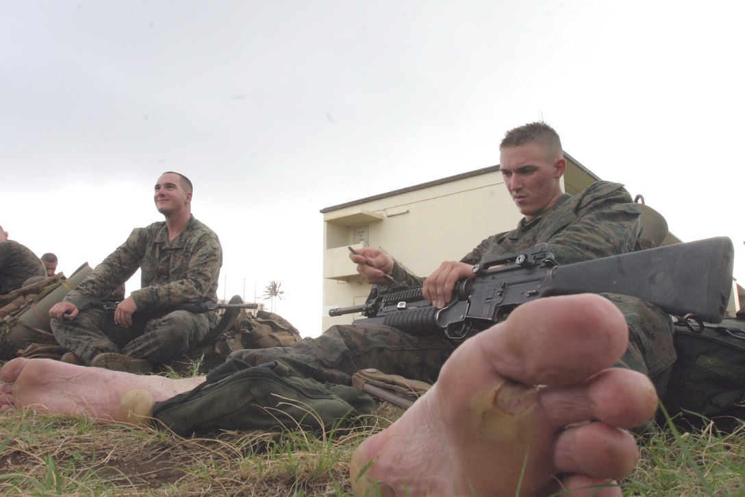 Lance Cpl. Kevin Neale, teamleader, 3rd squad, Lima Company, 3/3, cleans his weapon after the hike from Marine Corps Training Area, Bellows, back to K-Bay.  Neale recieved damage to his feet during the hike.