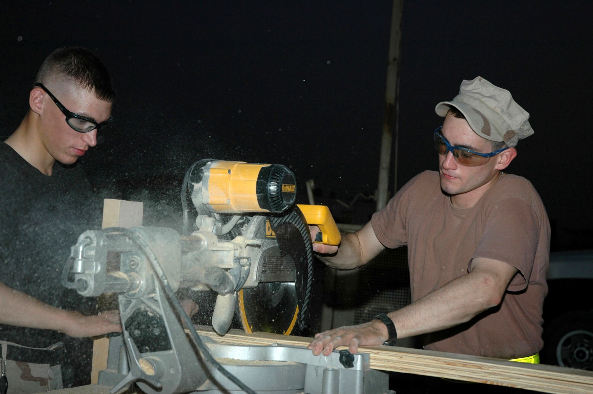 LOGISTICS SUPPORT AREA ANACONDA, Iraq -- Airmen 1st Class Scott Wise (left) and Adam Barnes with the 732nd Expeditionary Civil Engineer Squadron Detachment 6 vertical shop work to build 30 new 3,000-square-foot living quarters for Soldiers here.  Both Airmen are deployed from Dover Air Force Base, Del.  (U.S. Air Force photo by Senior Airman Chawntain Sloan)