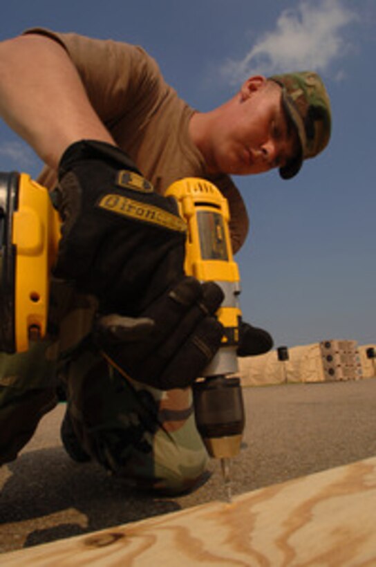 Senior Airman Joseph Spainhoward drives in screws as he constructs a cable protector at the Louis Armstrong International Airport in New Orleans, La., on Sept. 10, 2005. Spainhoward is a civil engineer assigned to the 78th Civil Engineering Squadron at Robbins Air Force Base, Ga., and is deployed with the 4th Air Expeditionary Group. Department of Defense units are mobilized as part of Joint Task Force Katrina to support the Federal Emergency Management Agency's disaster-relief efforts in the Gulf Coast areas devastated by Hurricane Katrina. 
