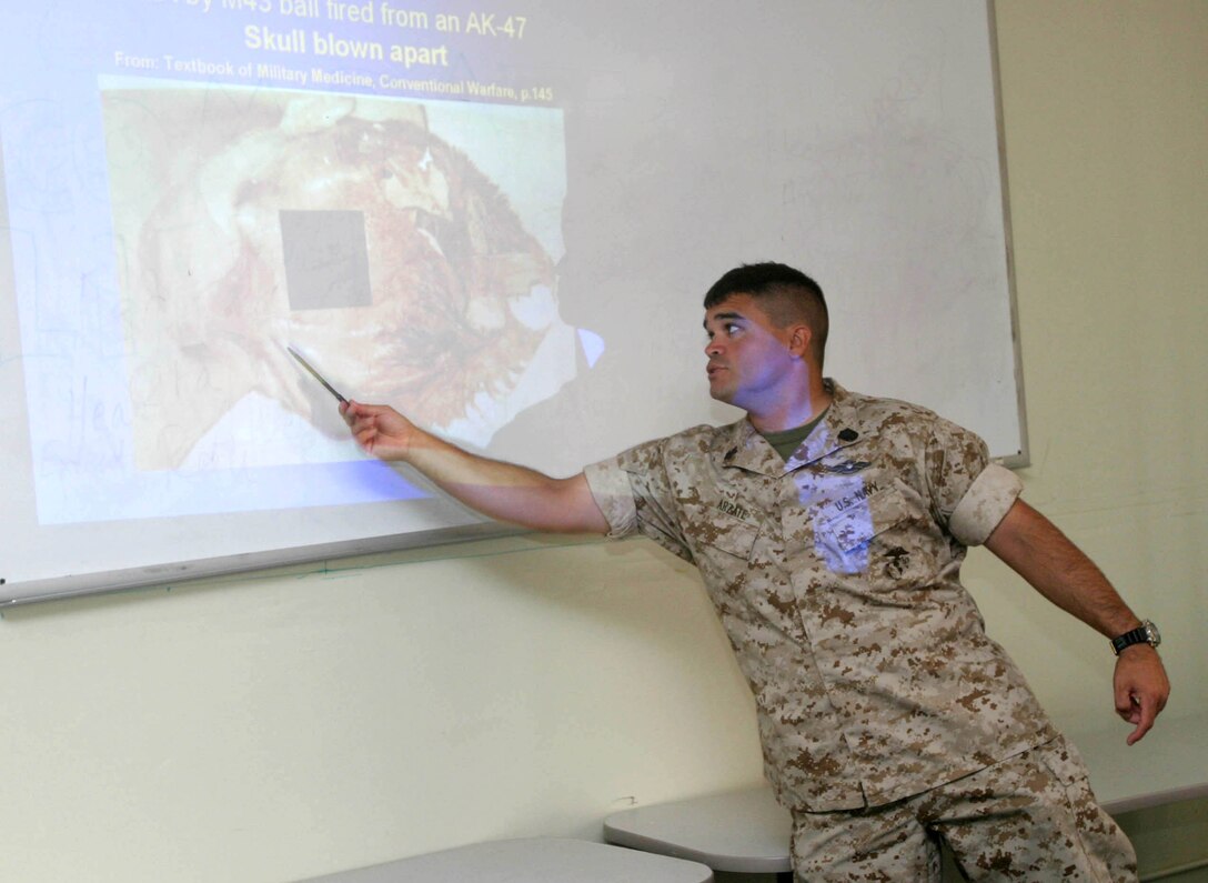 CAMP PENDLETON, Calif. (Sept. 16, 2005) - Navy Petty Officer 1st Class Jesse G. Arzate, a hospital corpsman with the 15th Marine Expeditionary Unit, shows a picture of a human head after it was struck by a bullet. Arzate taught more than 30 Marines during a scheduled medical brief about combat injuries, Sexually Transmitted Diseases, and field sanitation.