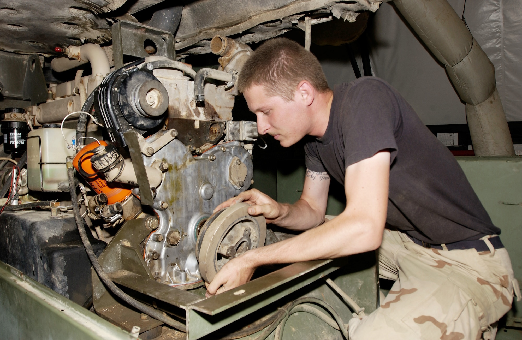 KIRKUK AIR BASE, Iraq -- Airman 1st Class Nolan Johnsen replaces a harmonic balancer on a generator.  He is assigned to the 727th Expeditionary Air Control Squadron Detachment 1 here.  The detachment's Airmen provide commanders and pilots with a real-time view of northern Iraq's airspace.  (U.S. Air Force photo by Tech. Sgt. Christopher Gish)               