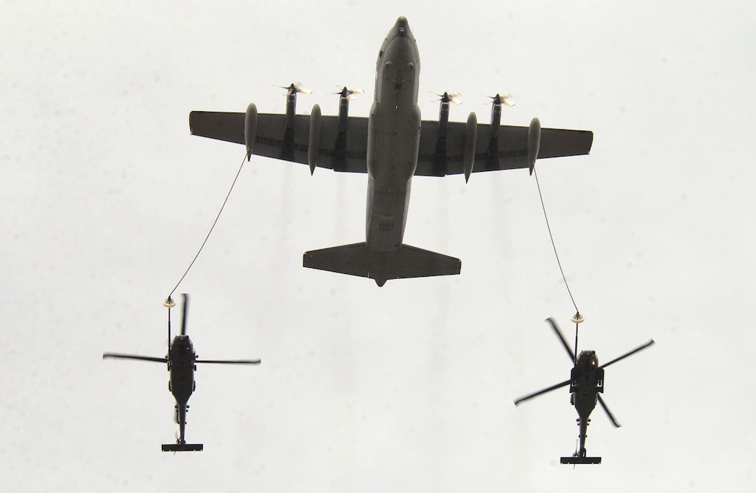 OVER ALASKA -- Two HH-60G Pave Hawk helicopters are refueled by an Alaska Air National Guard HC-130 P/N aircraft during Arctic Search and Rescue Exercise 05.  The exercise aimed to improve interoperability among U.S., Canadian and Russian pararescue forces.  (U.S. Air Force photo by Staff Sgt. Joshua Strang)