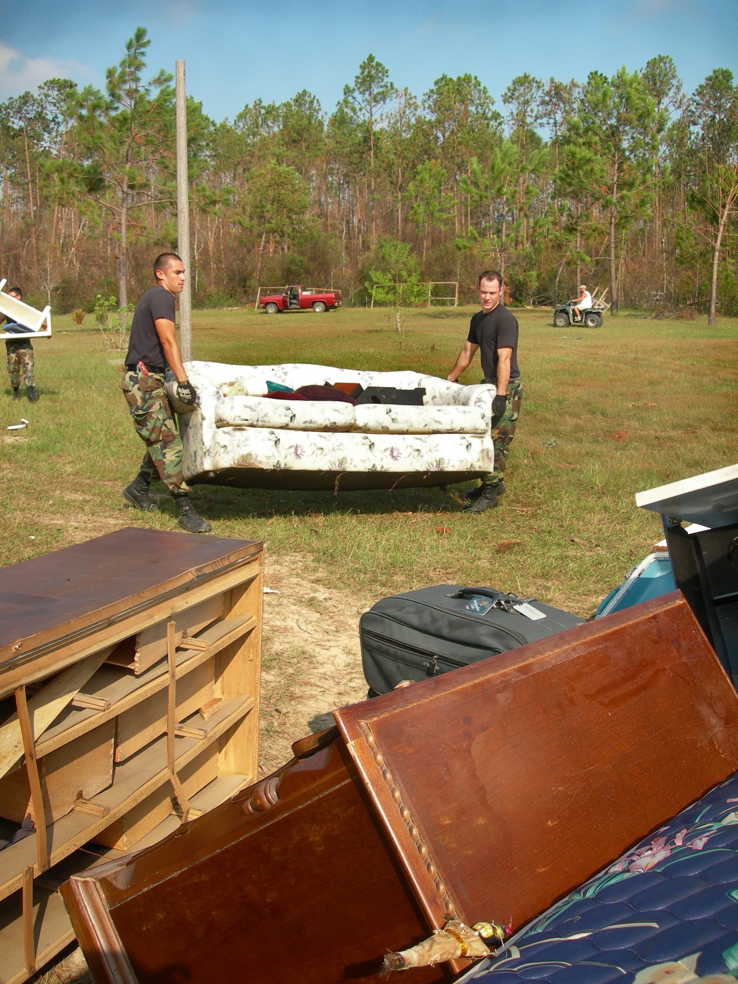 BILOXI, Miss. -- Senior Airman Adrian Silerio (left) and 2nd Lt. Scott Thomas dispose of a couch from a home that was damaged by Hurricane Katrina.  The Airmen are deployed to nearby Keesler Air Force Base from the 56th Civil Engineer Squadron at Luke AFB, Ariz.  (U.S. Air Force photo by 1st Lt. Brady Smith)