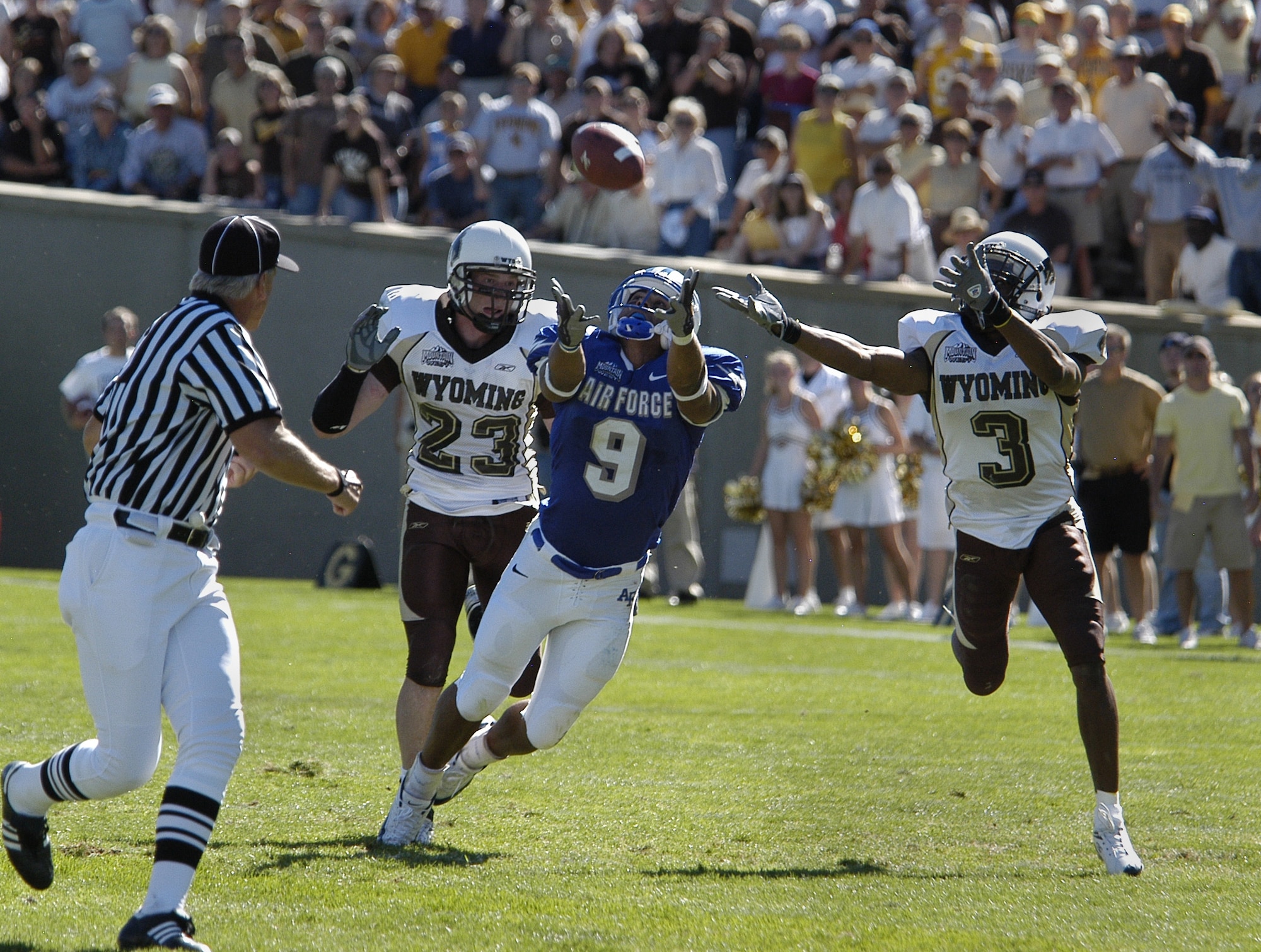 U.S. AIR FORCE ACADEMY, Colo. -- Air Force wide receiver Jason Brown reaches in vain for a pass between University of Wyoming free safety John Wendling, 23, and cornerback Terrance Butler, 3, during the Falcons last ditch drive here Sept. 17.  The Cowboys went on to edge the Falcons 29-28.  (U.S. Air Force photo by 2nd Lt. John Ross)