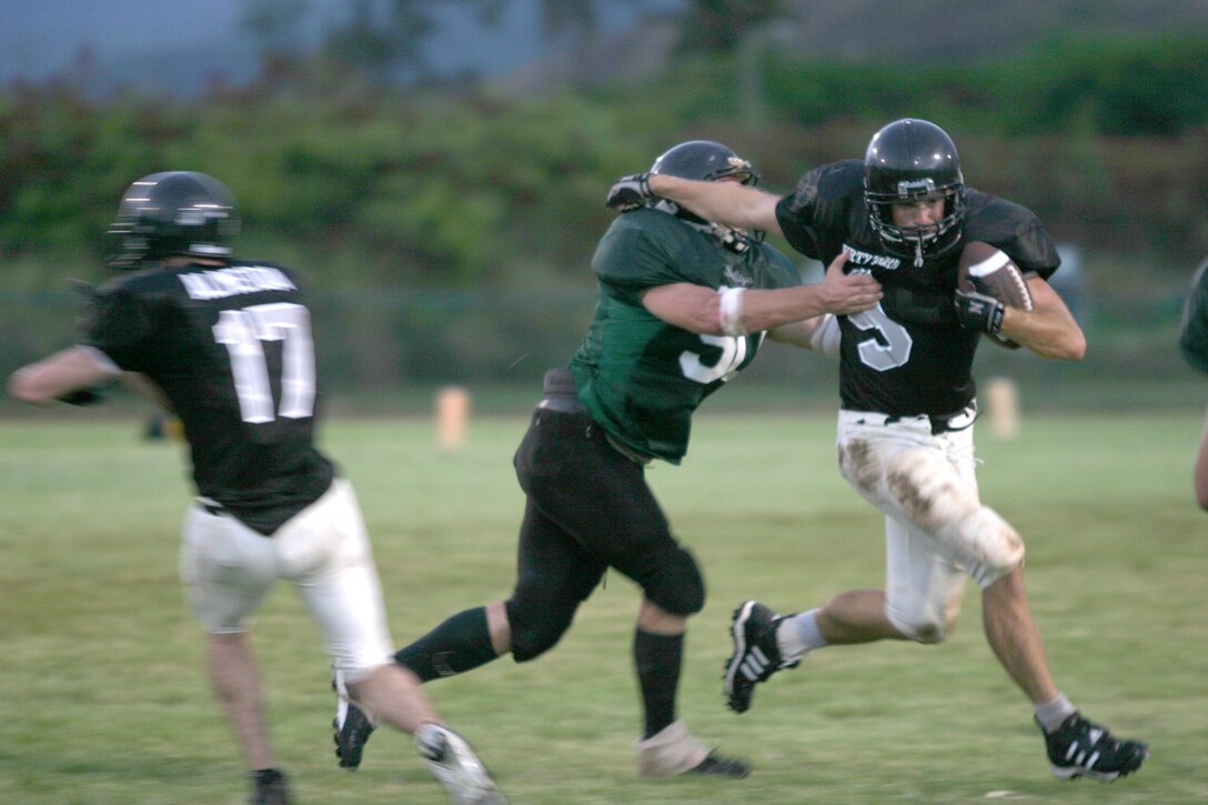 A 3rd Marines running back avoids the tackle as wide receiver Rick Almeida (left) prepares to make a block to aid his escape around the outside. Though the Dirty Third had their running game intact, it was not enough to stop the Bulldogs from taking the win.