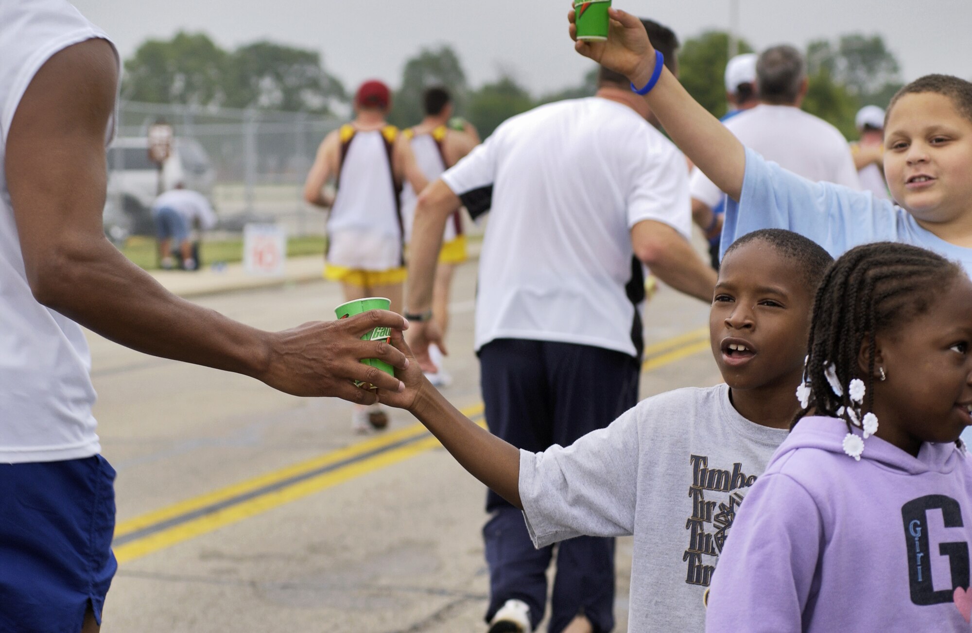 WRIGHT-PATTERSON AIR FORCE BASE, Ohio -- Raquij McCoy, 9, and Gregory Tate, 12, give water to participants in the U.S. Air Force Marathon on Sept. 17.  The runners traversed a grueling 26.2 miles here and in the local community.  (U.S. Air Force photo by Tech. Sgt. Tracy L. DeMarco)