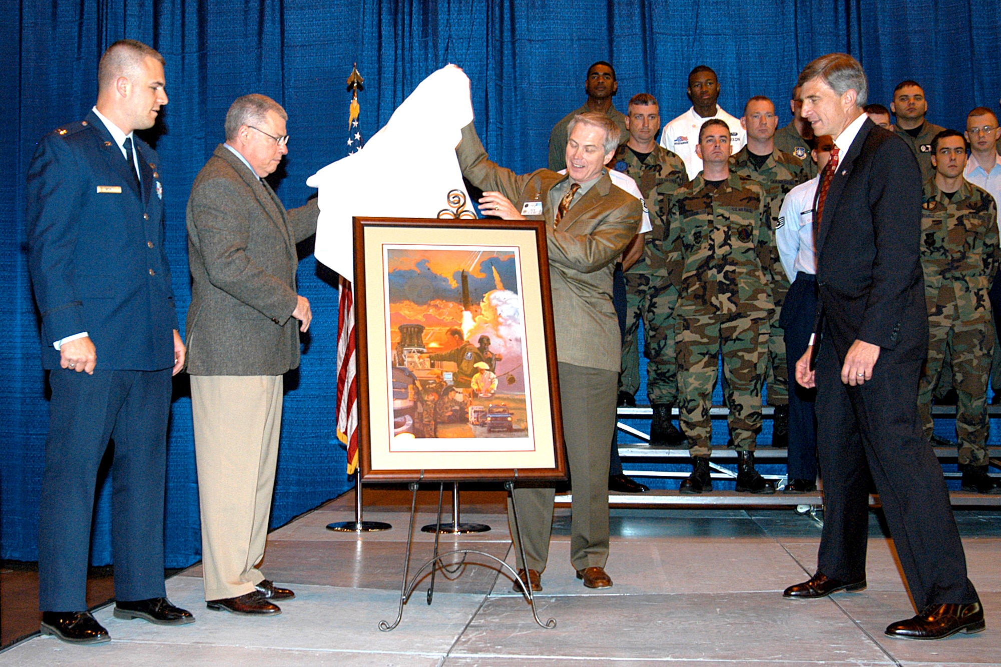 F.E. WARREN AIR FORCE BASE, Wyo. -- (From left) Capt. Warren Neary, retired Col. Roscoe Moulthrop and retired Maj. Gen. Jerry Perryman present a painting to Dr. Ronald Sega during the Peacekeeper missile deactivation ceremony Sept. 19.  The painting is a montage of the people who carried out the Peacekeeper mission throughout its 19-year history.  Dr. Sega is the undersecretary of the Air Force.  (U.S. Air Force photo by Liz Saucier) 