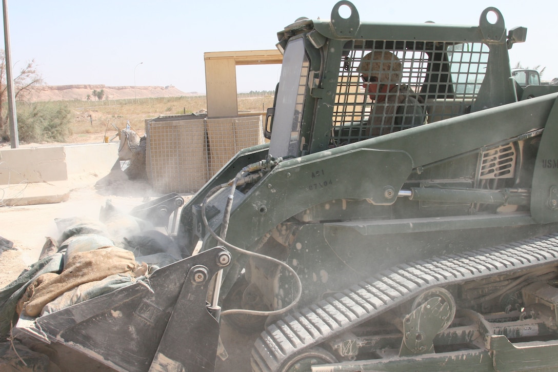 Staff Sgt. Remko Wouters, an engineer equipment operator with the Untouchables of Marine Wing Support Squadron 272 and Phoenix native, fills a Bobcat bucket with sand to place inside a Hesco barrier at Al Asad, Iraq, Sept. 21.