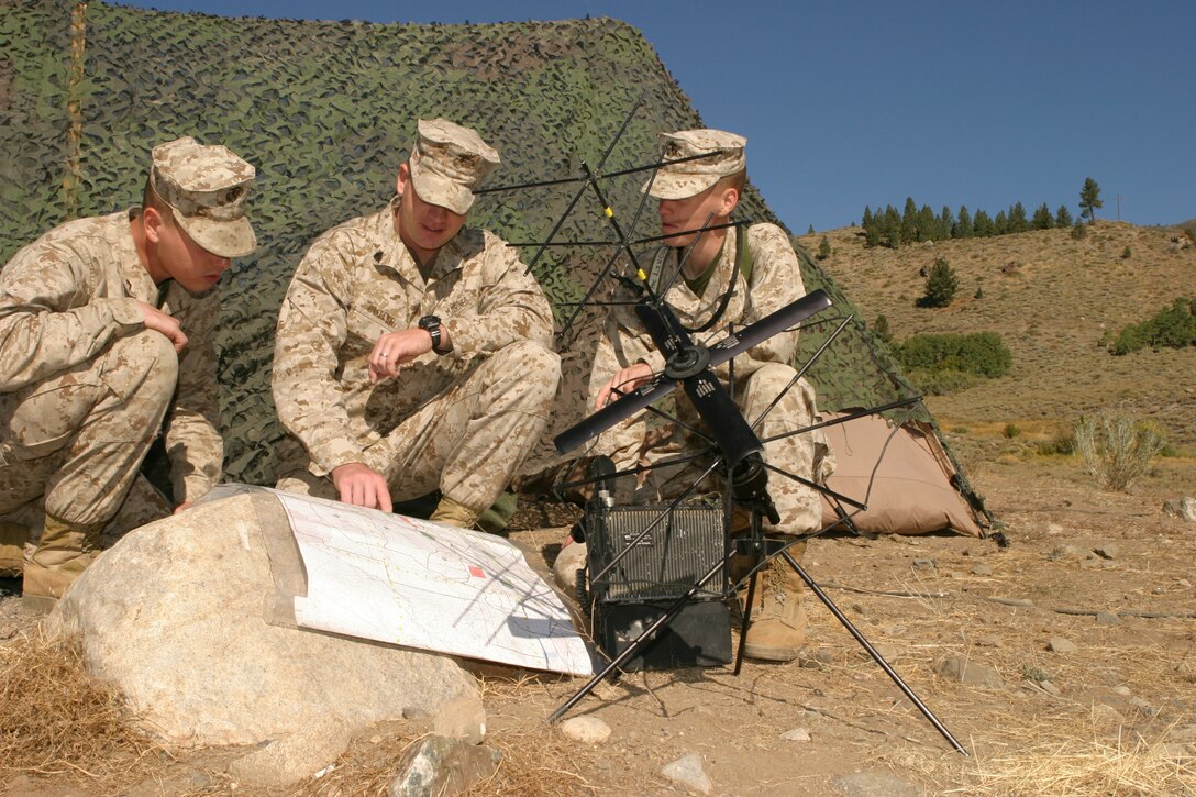 Sgt. Jason Butler, 1/3 Assistant Operations Chief and a native of Salt Lake City, Utah, goes over the finer points of a terrain map at a radio communications center with, from left, Pfc. Andrew Young, a field wireman from Rio Linda, Calif., and Pfc. Zane Lincoln, a field radio operator from San Diego, at the Marine Corps Mountain Warfare Training Center in Bridgeport, Calif.