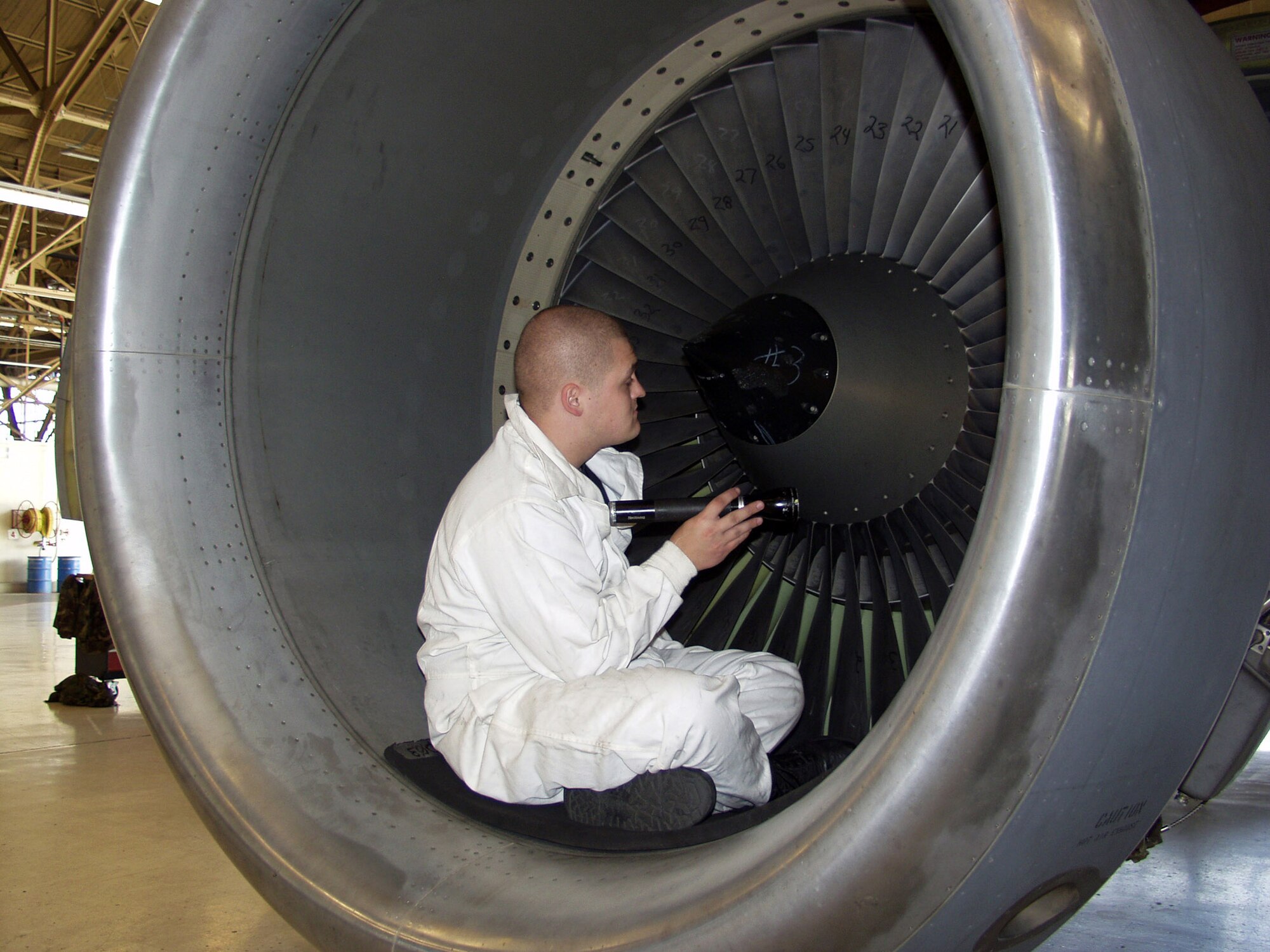FAIRCHILD AIR FORCE BASE, Wash. -- Senior Airman Jesse Rogers inspects an engine in a hangar here.  Airman Rogers, along with more than 300 Airmen from Grand Forks Air Force Base, N.D., have deployed here while their runway is under construction.  Airman Rogers is assigned to the 319th Maintenance Squadron.  (U.S. Air Force photo by Airman 1st Class Patrice Clarke)