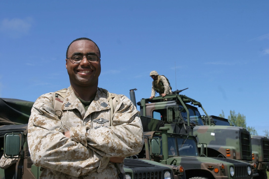 Petty Officer 1st Class Christopher Madden, a Navy Hospital Corpsman assigned to 3rd Radio Battalion, home based aboard Marine Corps Base Hawaii, Kaneohe Bay, stands in front of a convoy during training at Marine Corps Training Area, Bellows.