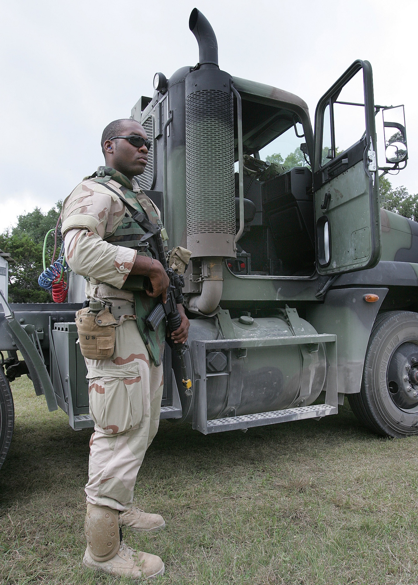 CAMP BULLIS, Texas -- Airman 1st Class Rahmon Harrell stands watch beside the tractor-trailer he drove during a convoy exercise at the Basic Combat Convoy Course here.  He is from McGuire Air Force Base, N.J.  (U.S. Air Force photo by Robbin Cresswell)