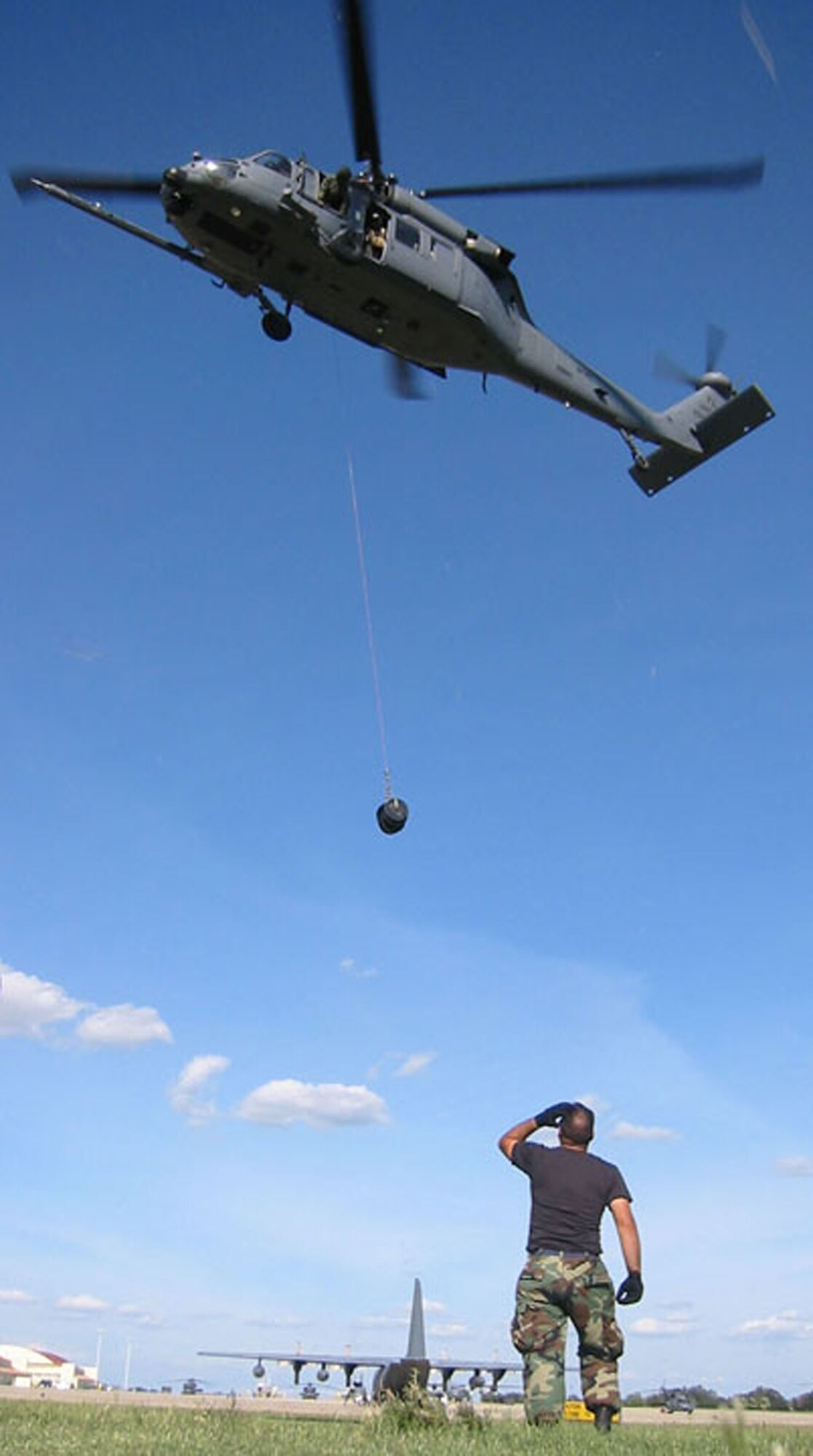 RANDOLPH AIR FORCE BASE, Texas -- Senior Airman Ronald Arroyo watches as a helicopter ascends with a 600-pound weight during an operational winch check Sept. 24.  Airman Arroyo is a crew chief assigned to the Air Force Reserve's 920th Rescue Wing, Patrick Air Force Base, Fla.  (U.S. Air Force photo by Tech. Sgt. Jason Tudor)