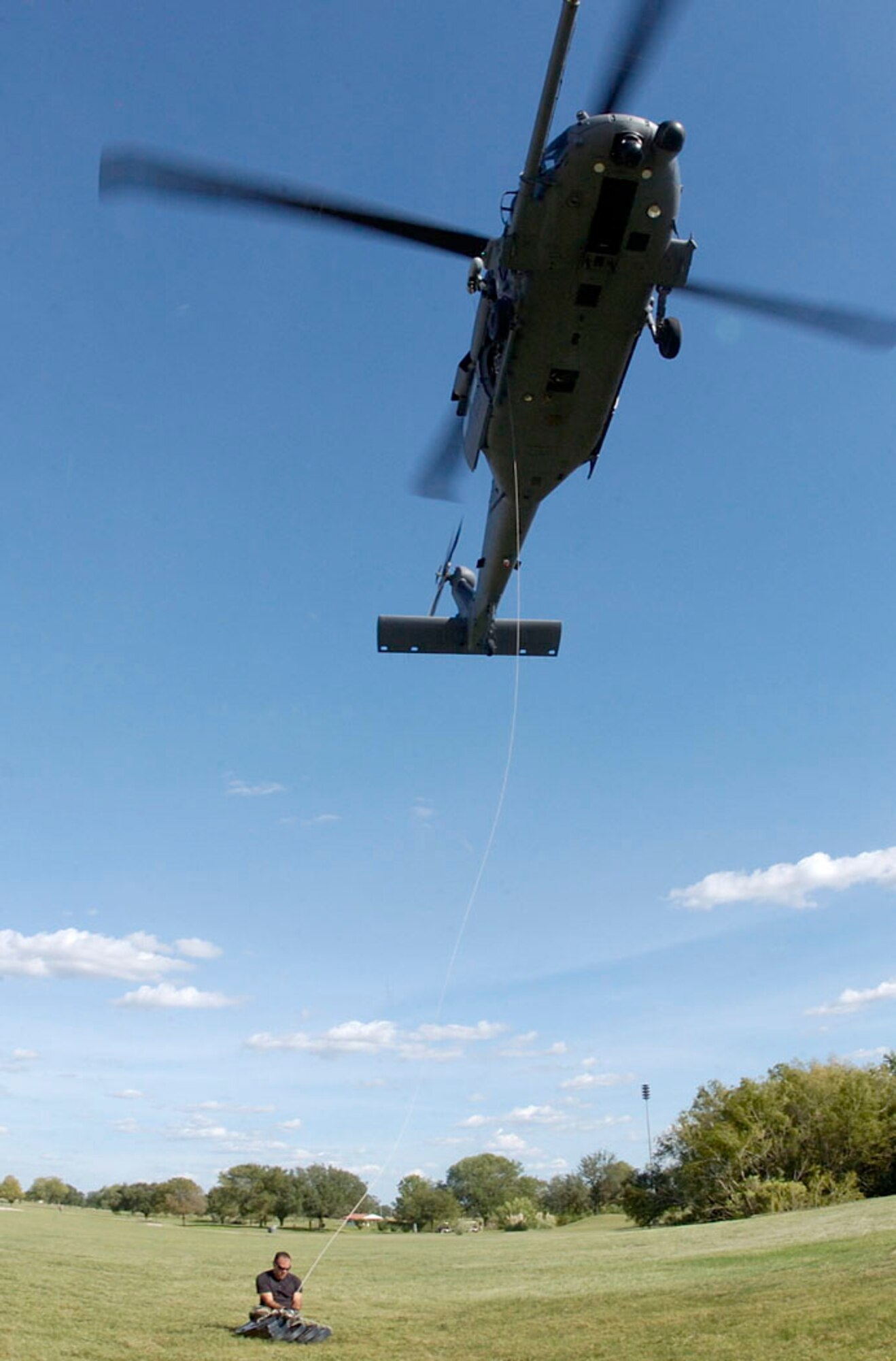 RANDOLPH AIR FORCE BASE, Texas -- Senior Airman Ronald Arroyo attaches a 600-pound weight to the rescue cable of an HH-60 Pave Hawk for an operational test prior to its departure on a search and rescue mission over southern Texas Sept. 24.  Airman Arroyo is a crew chief from the 920th Rescue Wing, Patrick Air Force Base, Fla.  (U.S. Air Force photo by Master Sgt Jack Braden.)
