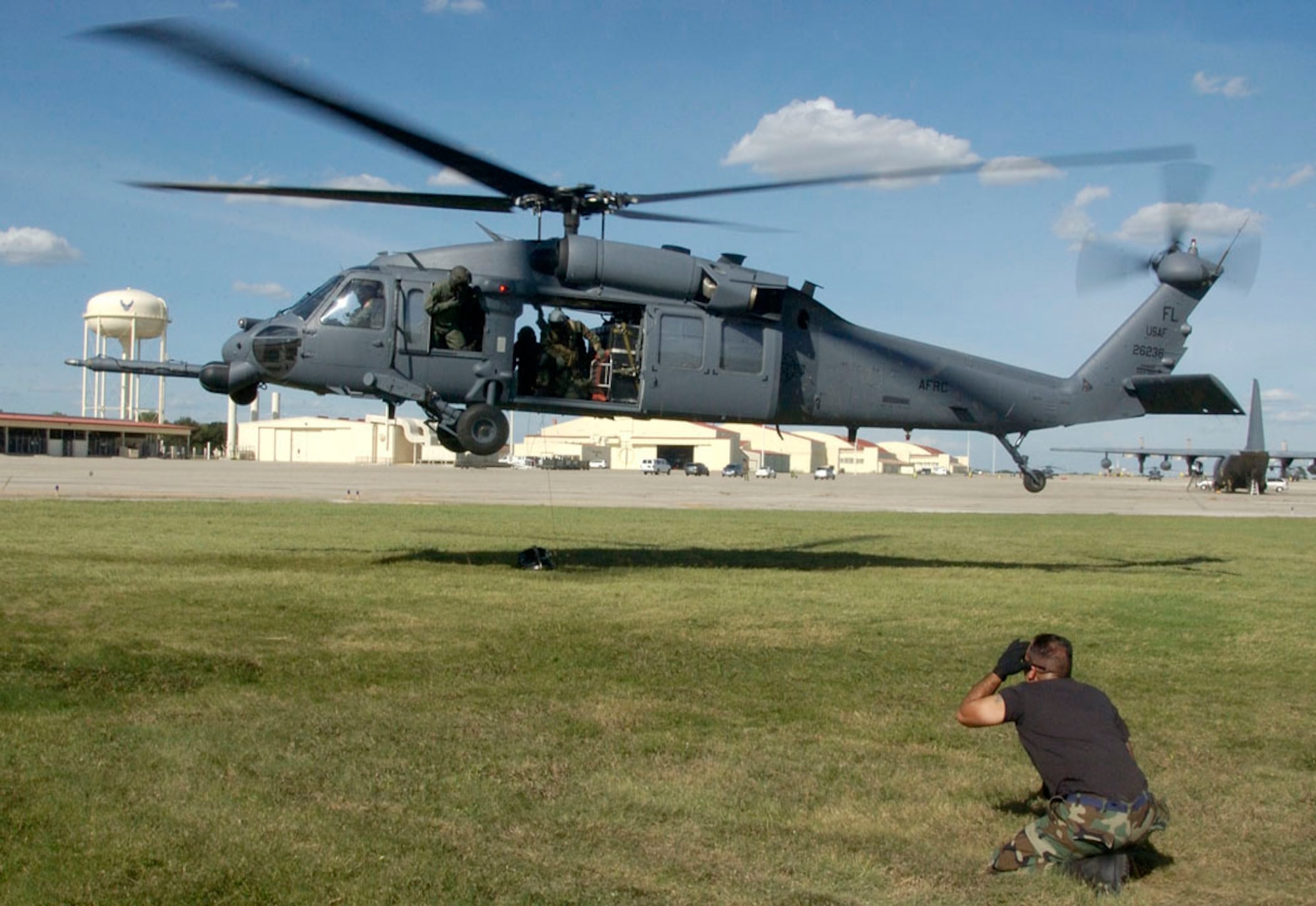 RANDOLPH AIR FORCE BASE, Texas -- Senior Airman Ronald Arroyo awaits clearance to detach a 600-pound weight from the rescue cable of an HH-60 Pave Hawk after an operational test prior to its departure on a search and rescue mission over southern Texas Sept. 24.  Airman Arroyo is a crew chief from the 920th Rescue Wing, Patrick Air Force Base, Fla.  (U.S. Air Force photo by Master Sgt Jack Braden.)