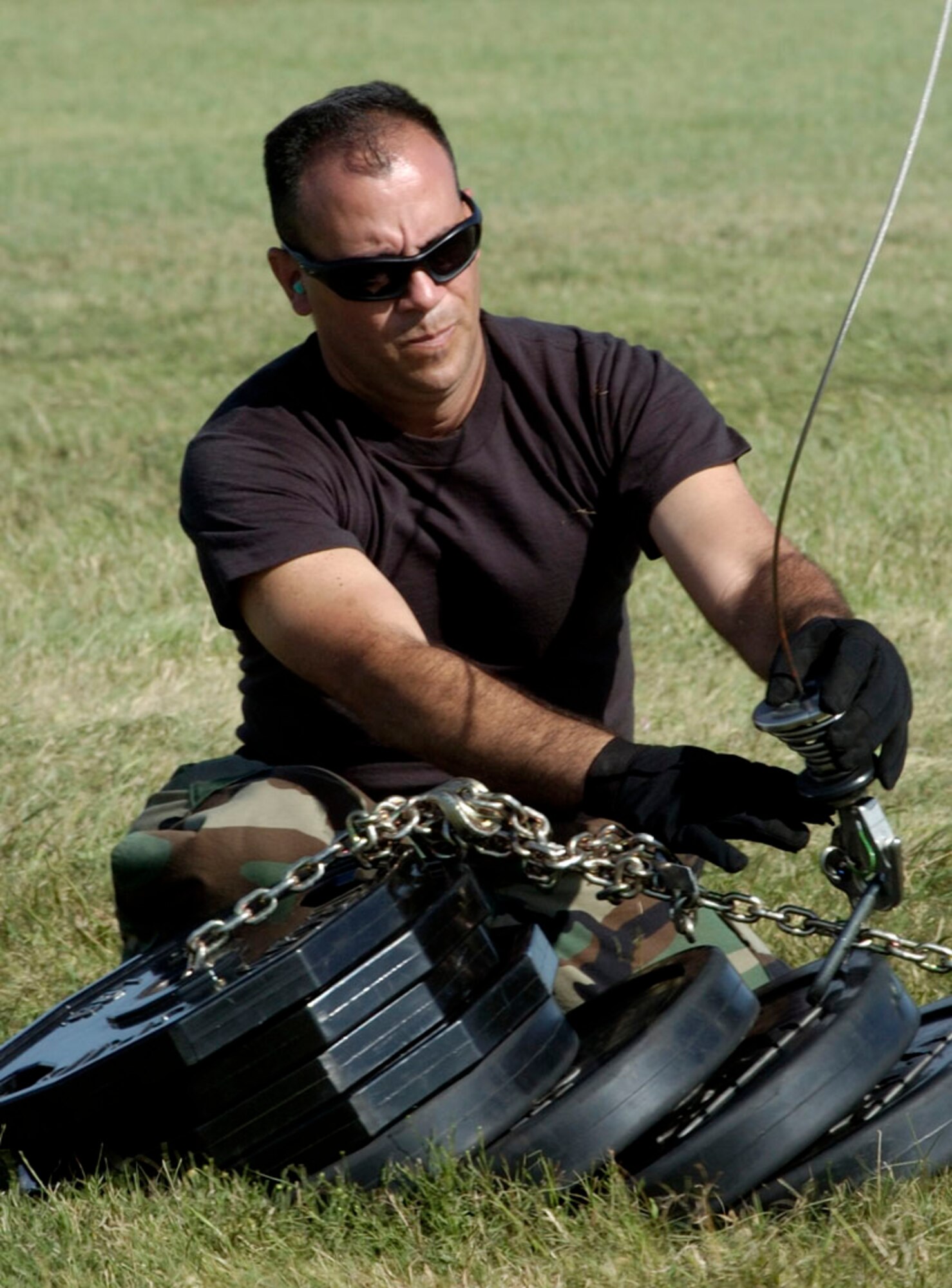 RANDOLPH AIR FORCE BASE, Texas -- Senior Airman Ronald Arroyo attaches a 600-pound weight to the rescue cable of an HH-60 Pave Hawk for an operational test prior to its departure on a search and rescue mission over southern Texas Sept. 24.  Airman Arroyo is a crew chief from the 920th Rescue Wing, Patrick Air Force Base, Fla.  (U.S. Air Force photo by Master Sgt Jack Braden.)