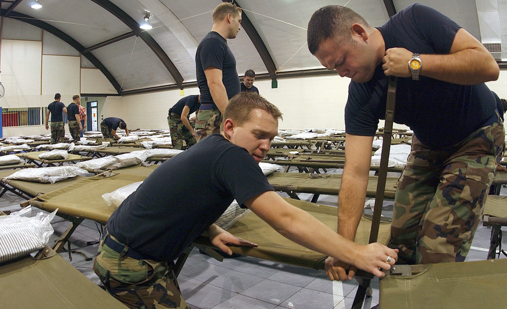 ABILENE, Texas - Senior Airmen Chad Thomas and Jason Fuentes assemble a cot Sept. 23 at an American Red Cross shelter here. About 100 Airmen from Dyess Air Force Base volunteered to prepare three shelters for more than 450 evacuees seeking refuge from Hurricane Rita.(U.S. Air Force photo by Airman 1st Class Chris Walkenhorst)