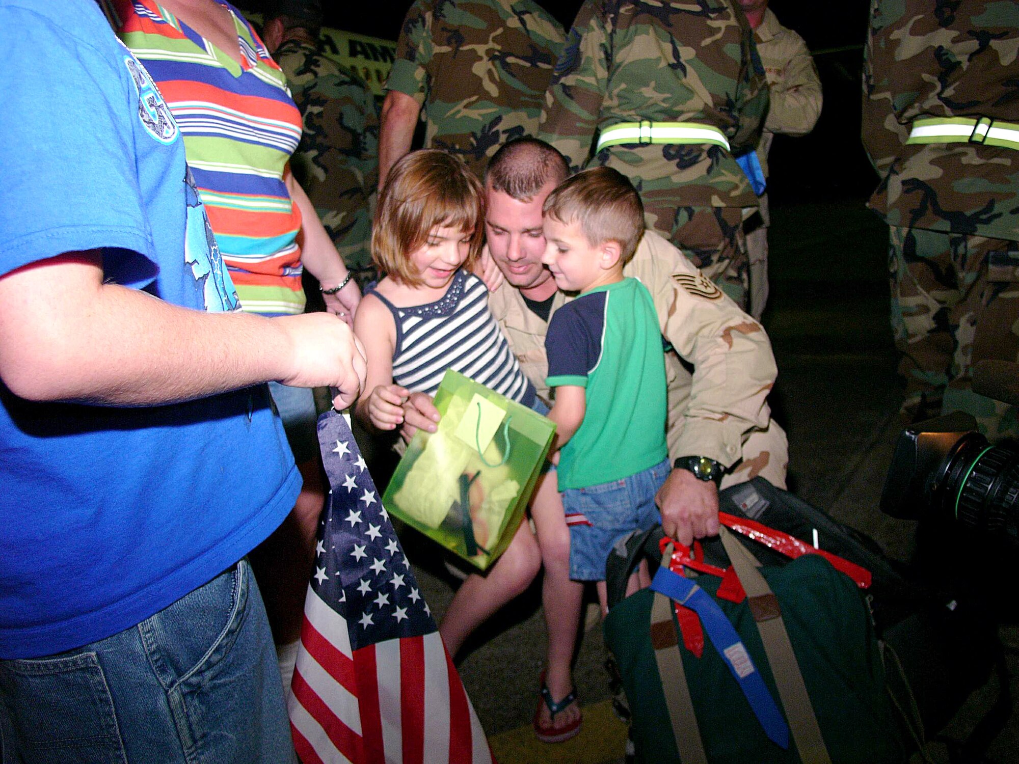 ELLINGTON FIELD, Texas -- Tech. Sgt. W.T. Roy hugs his 7-year-old daughter, Mallori, and 3-year-old son, Branson, after returning from a deployment with the 147th Fighter Wing to Balad Air Base, Iraq.  Many of the Airmen's families were there to meet them despite being evacuated for Hurricane Rita.  (U.S. Air Force photo by Master Sgt. Bob Blauser)
