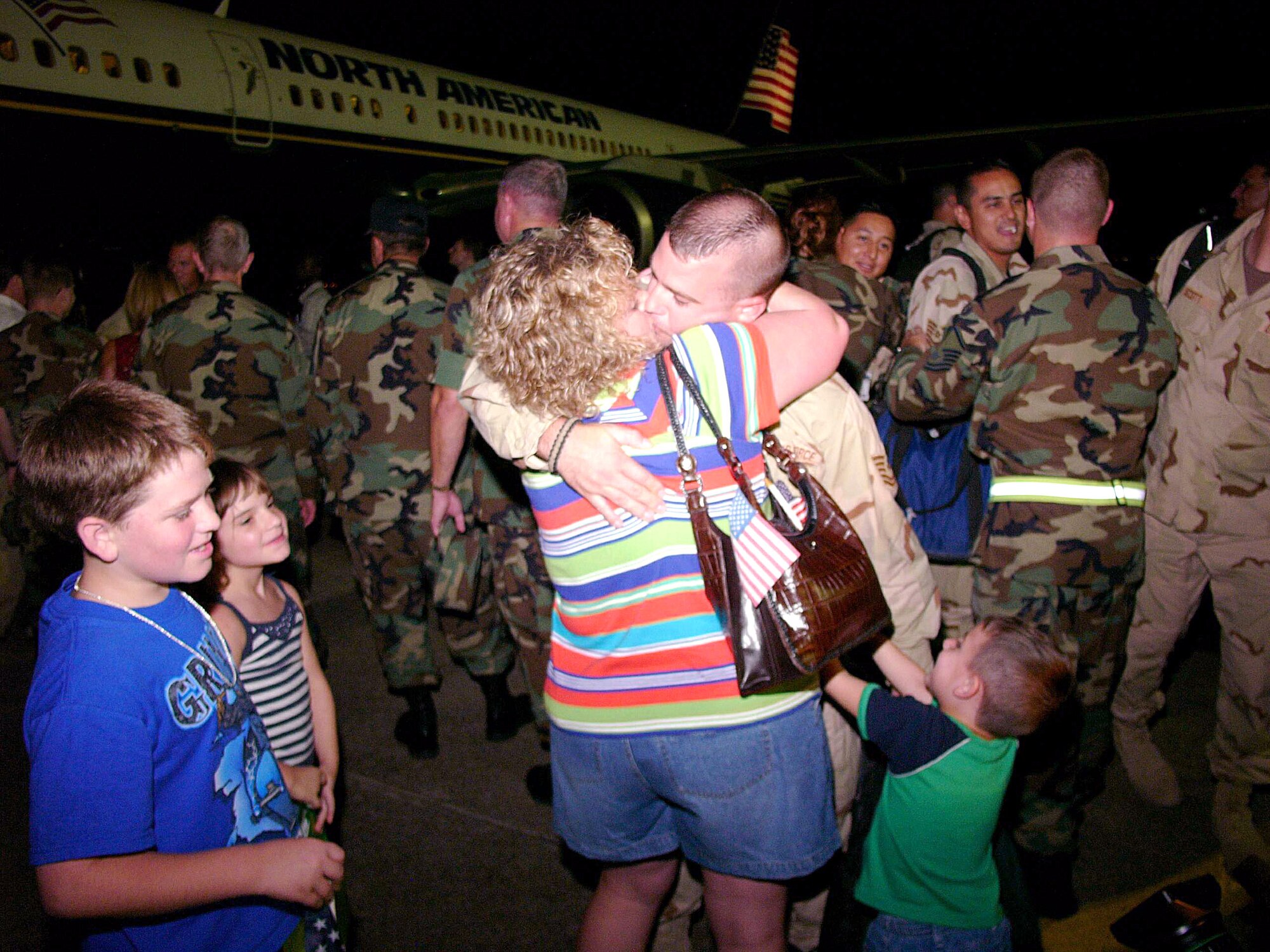 ELLINGTON FIELD, Texas -- Tech. Sgt. W.T. Roy is greeted by his wife, Misti, and children (from left) Talor, 12, Mallori, 7, and Branson, 3.  Sergeant Roy was deployed with the 147th Fighter Wing to Balad Air Base, Iraq.  Many of the Airmen's families were there to meet them despite being evacuated for Hurricane Rita.  (U.S. Air Force photo by Master Sgt. Bob Blauser)

