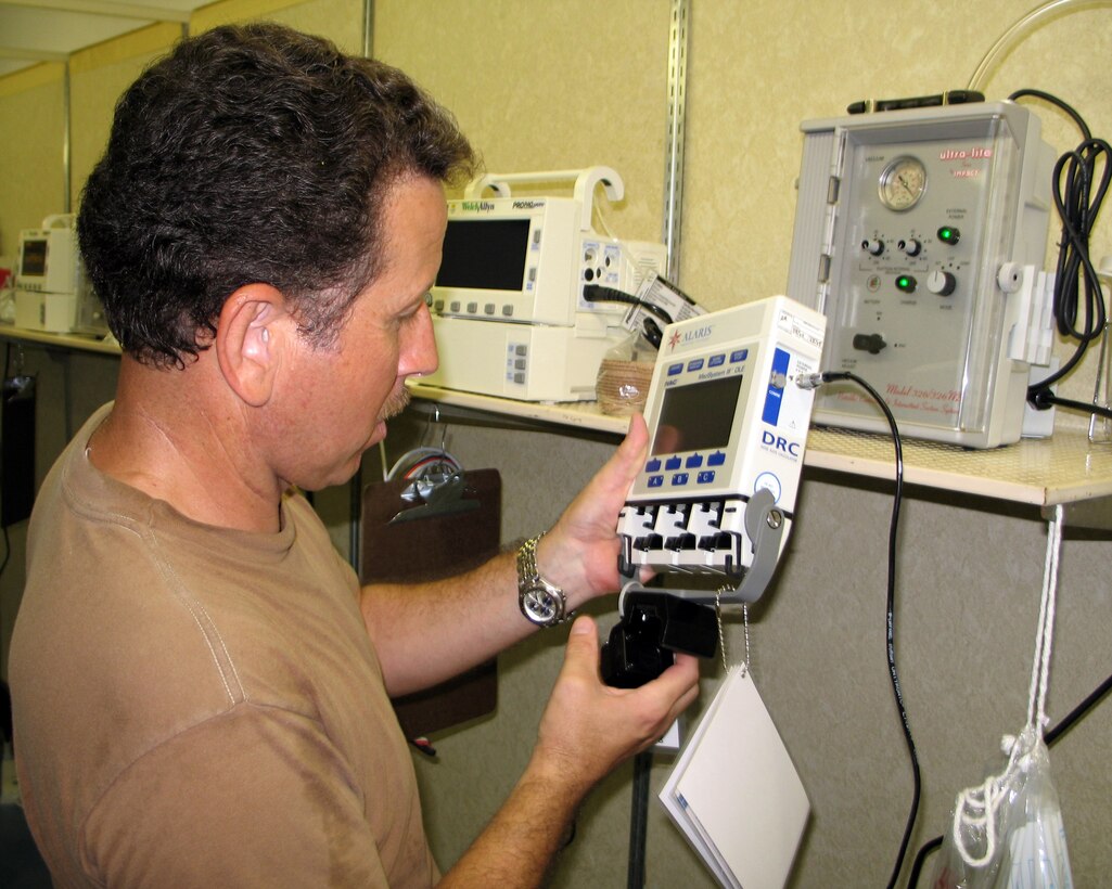ELLINGTON FIELD, Texas -- Tech. Sgt. Gilbert Cisneros Jr. sets up medical equipment before the opening of a 10-bed medical treatment facility here. Sergeant Cisneros is a member of Task Force Compassion established in support of the Hurricane Rita relief effort. (U.S. Air Force photo by Master Sgt. Lee Roberts)