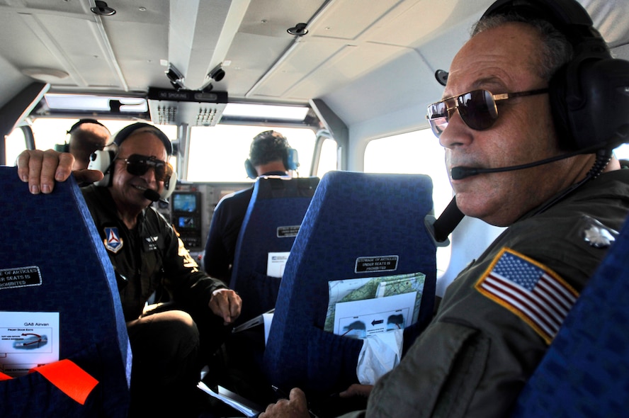 OVER SABINE LAKE, Texas -- Lt. Cols. Paul Salos (left) and C.J. Faas (right), aid an observer/photographer Sept. 26 in logging altitude, direction of camera, latitude and longitude, and photo frame number during a photo reconnaissance flight. The colonels are pilots with the Civil Air Patrol.  (U.S. Air Force photo by Master Sgt. Lance Cheung)