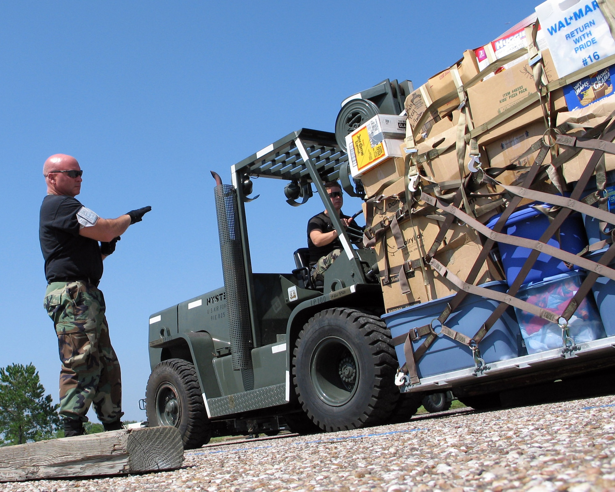ELLINGTON FIELD, Texas -- Senior Master Sgt. Rick Curtis (left) marshals a pallet of humanitarian supplies onto the ramp here destined to support the Hurricane Rita relief effort. The supplies, moved Sept. 26, were donated by the Missouri Air National Guard. Sergeant Curtis is with the 136th Aerial Port Squadron at Naval Air Station-Joint Reserve Base Fort Worth, Texas. (U.S. Air Force photo by Master Sgt. Lee Roberts)