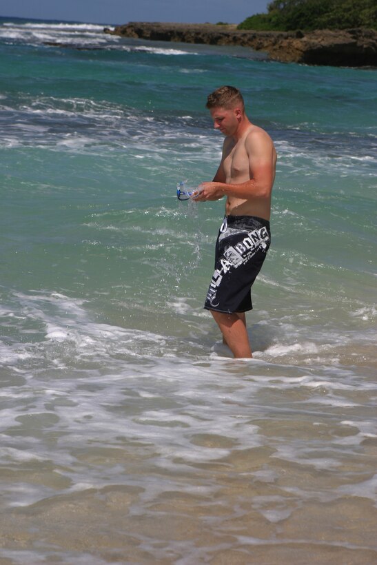 Sgt. Phillip H. Cuppernell, postal clerk, Headquarters Battalion, Marine Corps Base Hawaii, Kaneohe Bay, wipes his goggles off with saliva before he begins a spearfishing session at North Beach, on MCBH, Kaneohe Bay.  Cuppernell says this method prevents the goggles from getting foggy while under the water.