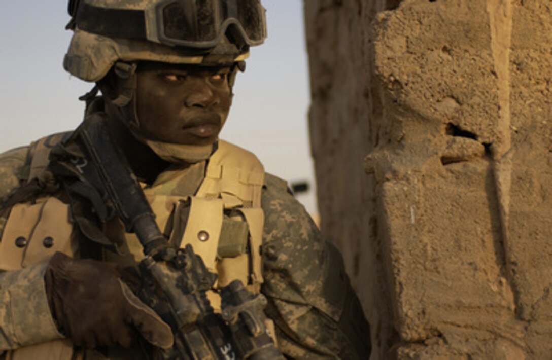 U.S. Army Pvt. Kueth Dolvony provides security on the backside of a house during a search for weapons caches outside Rawah, Iraq, on Sept. 27, 2005. Dolvony is assigned to Charlie Troop, 4th Battalion, 14th Cavalry, 2nd Platoon. 