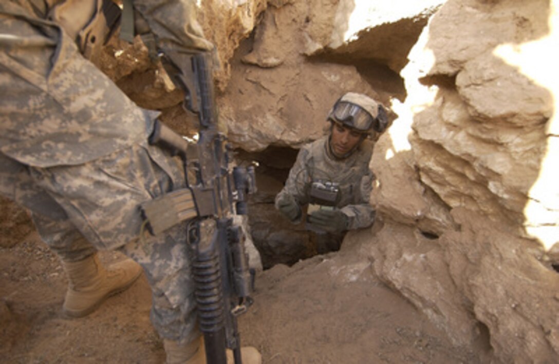 U.S. Army Staff Sgt. Bill Hatzman looks over an explosive device prior to detonating it inside a cave that could be used as a weapons cache outside Rawah, Iraq, on Sept. 27, 2005. Hatzman is assigned to 2nd Platoon, 14th Cavalry, 4th Battalion. 