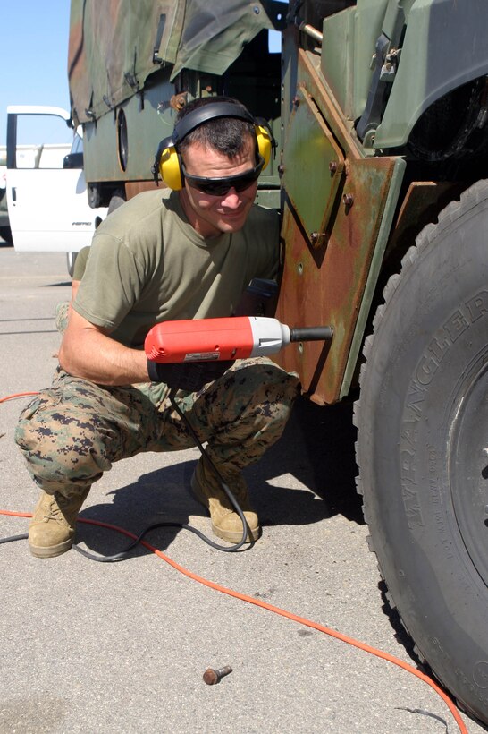 Staff Sgt. Pablo Torrez, maintenance chief of the 15th Marine Expeditionary Unit, and a native of Keller, Texas, removes class 2 armor from the front of a humvee in their motor pool at Camp Del Mar here. The 15th MEU is replacing their class 2 humvee armor with the Mack 1 armor kit in preparation for their deployment next year.