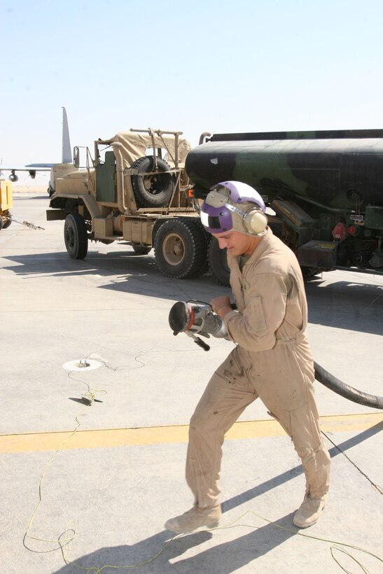 Corporal Joseph Daum, a motor transport driver turned refueler operator for Marine Wing Support Squadron 272 and Los Angeles native, pulls a hose from a 5,000-gallon tanker toward a KC-130 for fueling, Sept. 29, at Al Asad, Iraq. Marines from MWSS-272, based at Marine Corps Air Station New River, N.C., are keeping Al Asad?s fuel supply flowing, or rolling in their case.