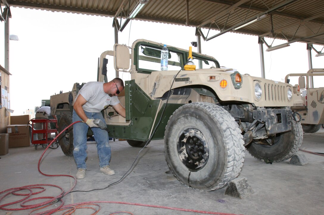 David Jarvis, a mechanic from Honeywell Technical Solutions Incorporated and Madison, Fla., native, works on a Marine armor kit for a 2nd Marine Aircraft Wing humvee, Sept. 29, at Al Asad, Iraq. A Marine-Civilian team recently arrived here from Al Taqaddum, Iraq, to upgrade the armor on 60 of the Wing?s humvees.