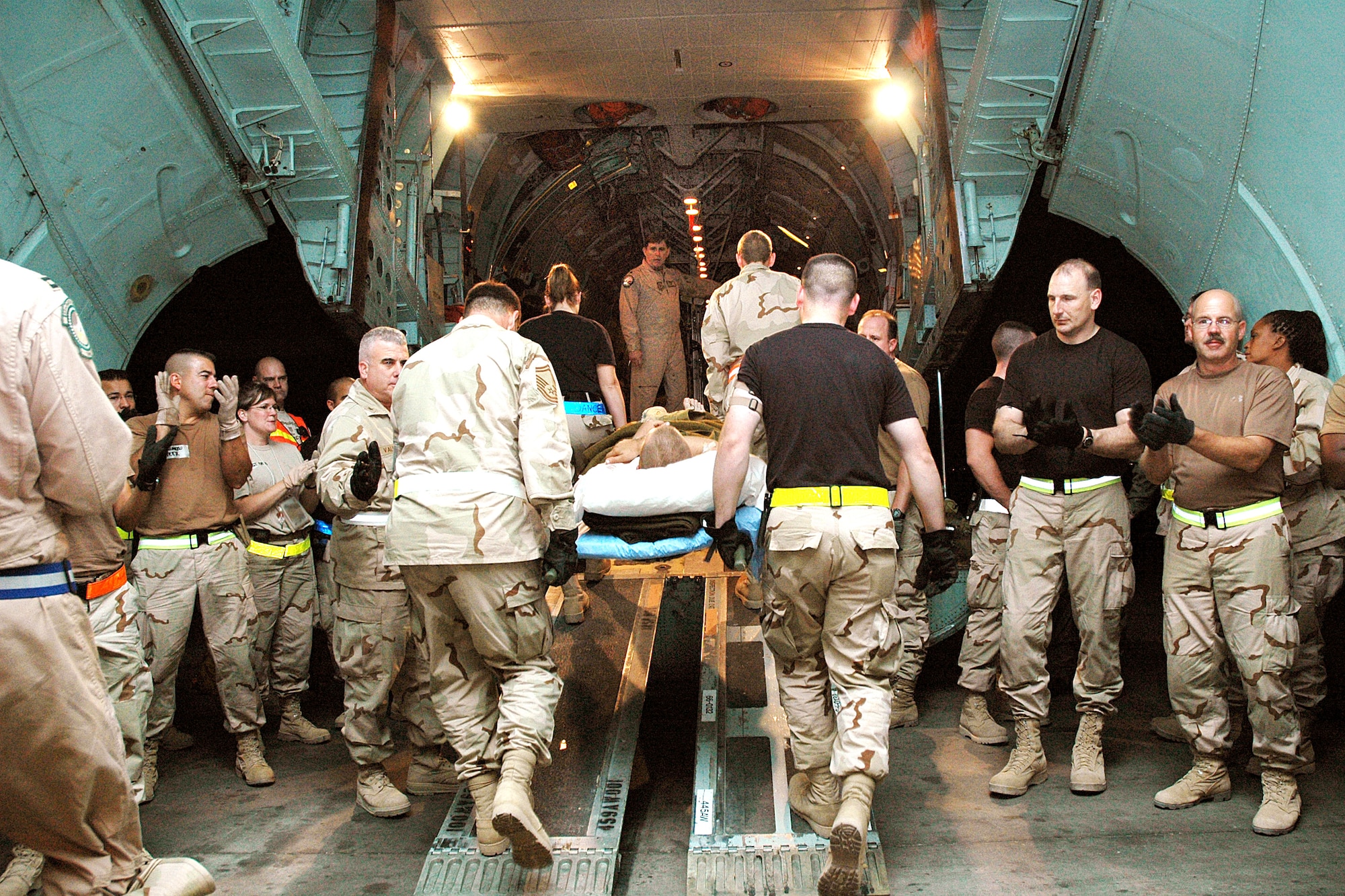 BALAD AIR BASE, Iraq -- Airmen applaud and cheer, thanking injured Soldiers and Marines for their service in the war on terrorism as they are brought aboard the last C-141 Starlifter aeromedical evacuation flight from a combat zone Sept. 29. The aircraft, assigned to Air Force Reserve Command's 445th Airlift Wing at Wright-Patterson Air Force Base, Ohio, transported the injured servicemembers to Landstuhl Regional Medical Center, Germany, for treatment. The flight concluded more than three decades of overseas aeromedical evacuation missions with the aircraft, beginning during the Vietnam War. (U.S. Air Force photo by Maj. Robert Couse-Baker)