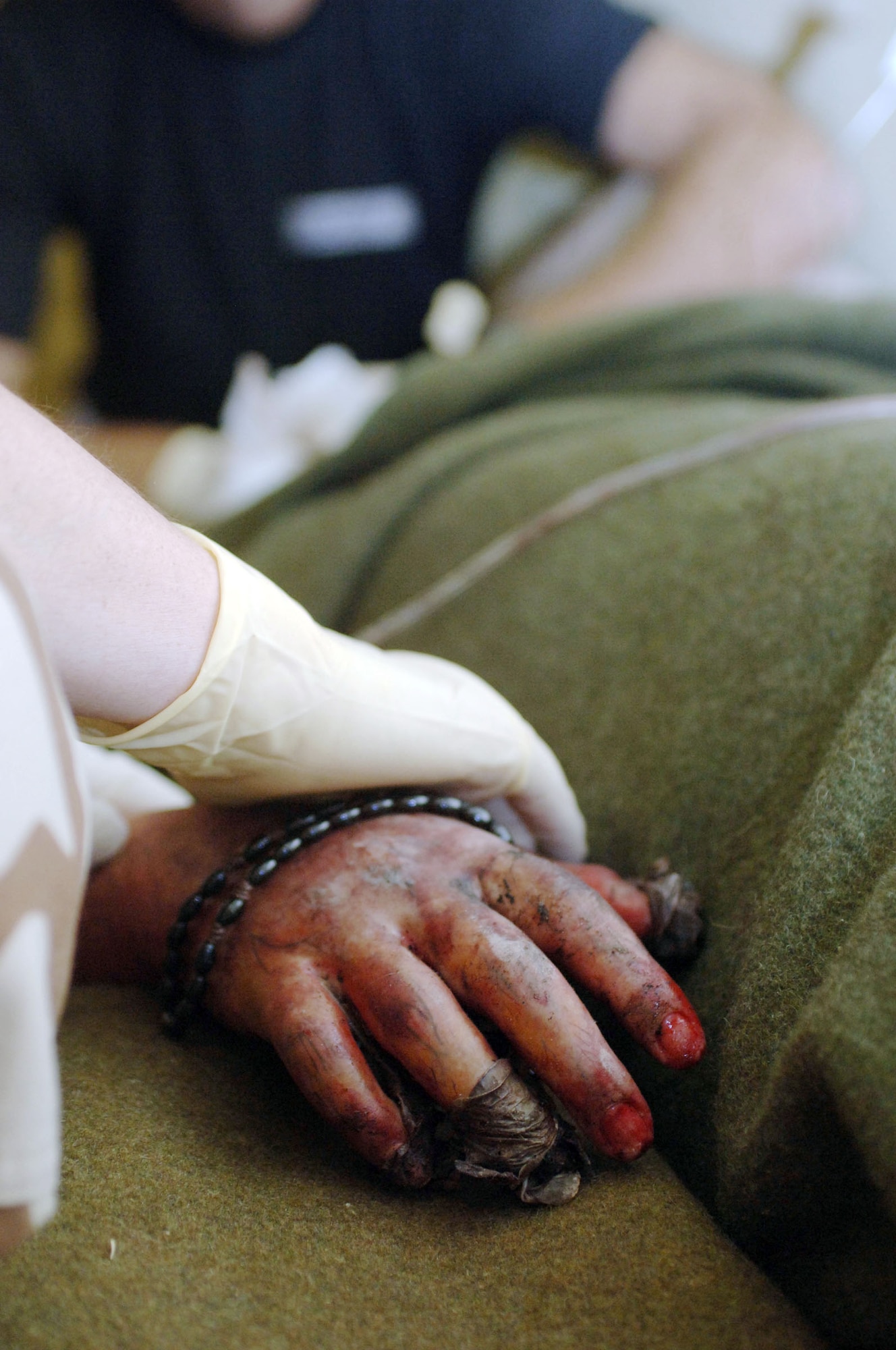 BALAD AIR BASE, Iraq -- A supporting hand rests on an Iraqi victim of a suicide car bomb attack in the town of Balad near here. (U.S. Air Force photo/Senior Airman Anthony A. Williams)