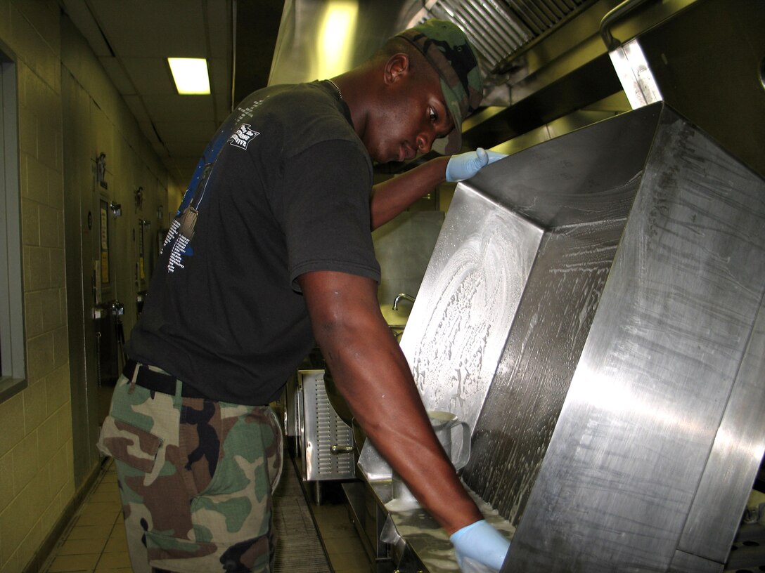 050927-F-1415J-001ELLINGTON FIELD, Texas -- Airman 1st Class Ilias Simpson washes dishes after serving lunch to permanent party and deployed servicemembers here. He is with the 136th Services Flight that arrived here Sept. 24 from Fort Worth, Texas, to help out with hurricane-relief efforts. (U.S. Air Force photo by Senior Airman Danielle Johnson)