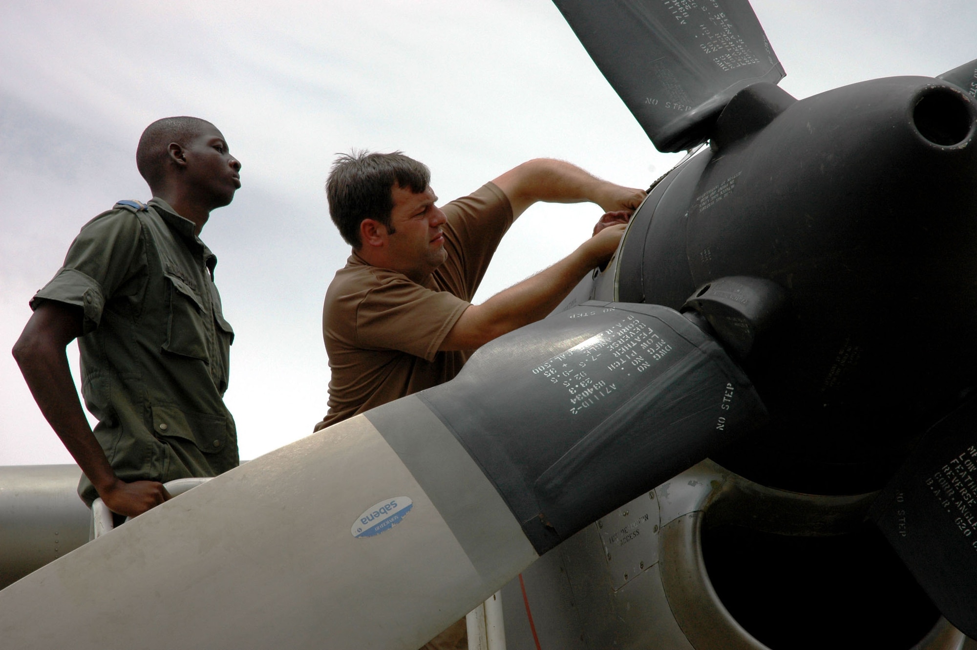 NIAMEY, Niger -- A 6th Special Operations Squadron maintenance instructor examines components of a turboprop engine on the Niger Air Force C-130 here while a Nigerian maintainer learns some new techniques during a joint training exercise Aug. 15. (U.S. Air Force photo by Capt. Tom Montgomery)