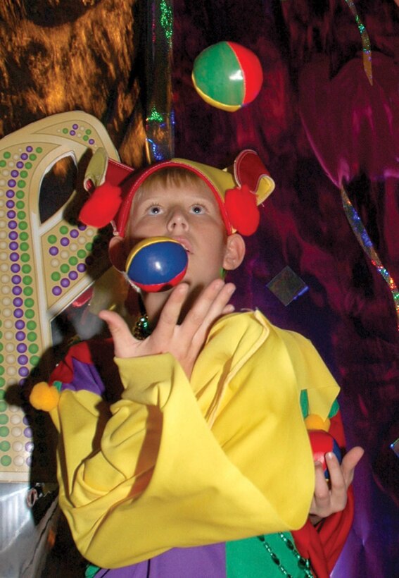 William Rundle, 12-year-old juggler and unicyclist, greets guests with his juggling skills as they enter Infinities for the Marine Corps Community Services annual Mardi Gras party Friday. MCCS asked guests to donate $10 to the Navy Marine Corps Relief Society?s Hurricane Katrina Fund instead of paying admission to the party. Some guests gave much more.
